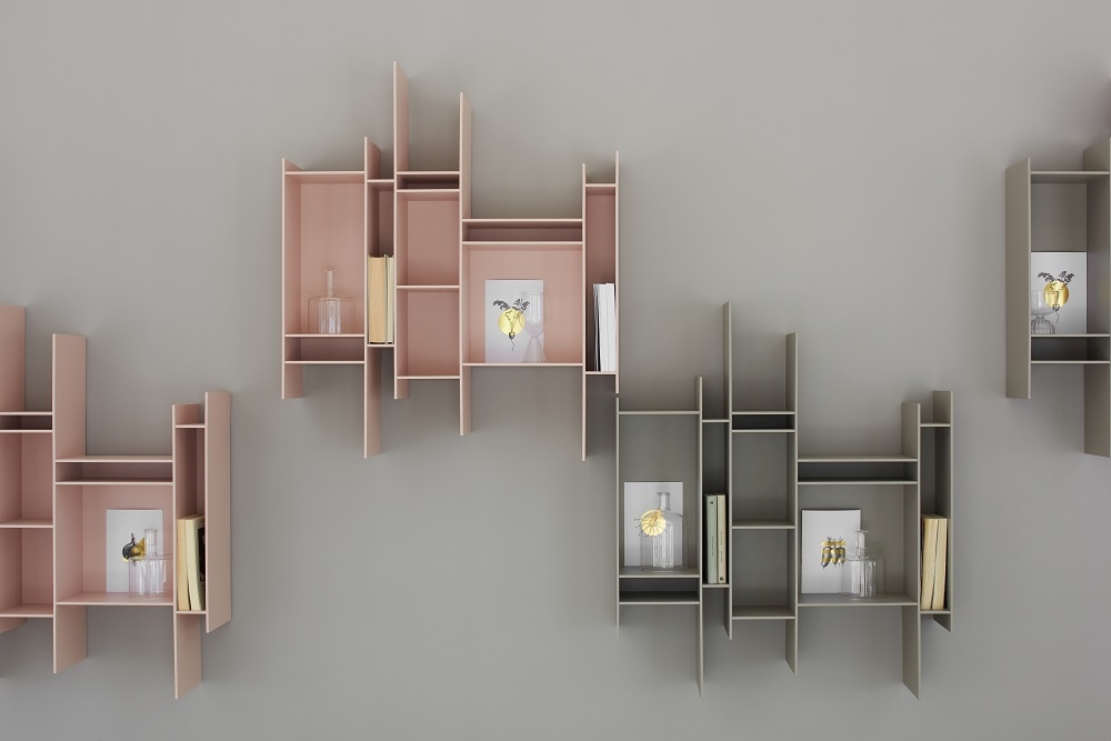 Farbiges Randomito Regalsystem von MDF Italia an einer Wand, mit Büchern und Dekoration.