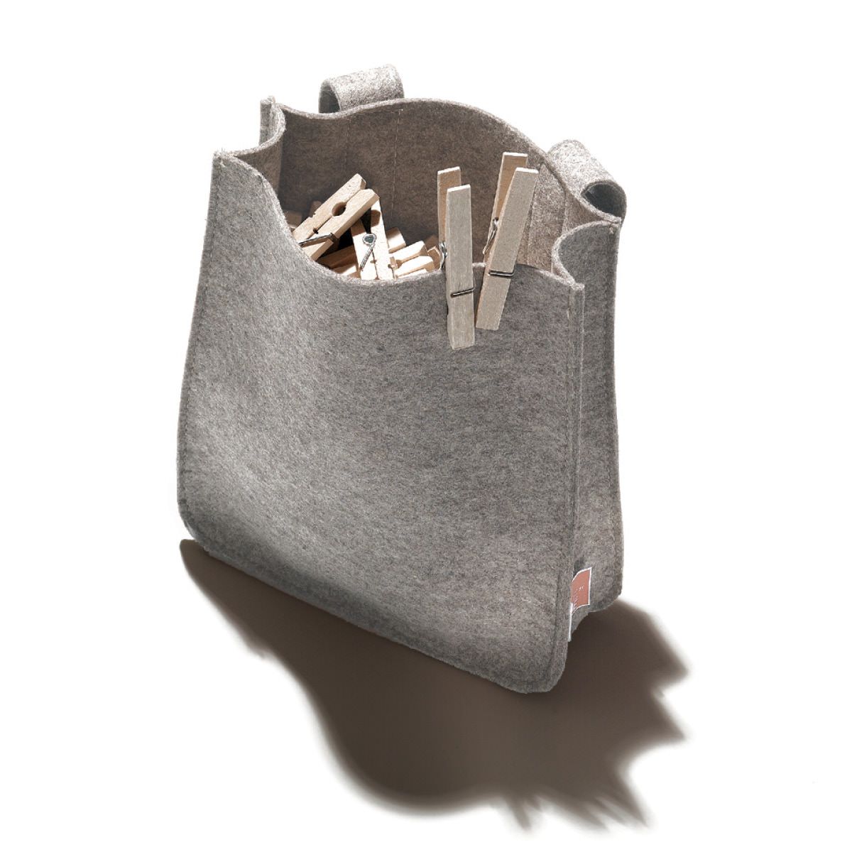 Grauer Klammernbeutel Filius aus Filz, gefüllt mit Wäscheklammern, für die Aufbewahrung und Organisation.