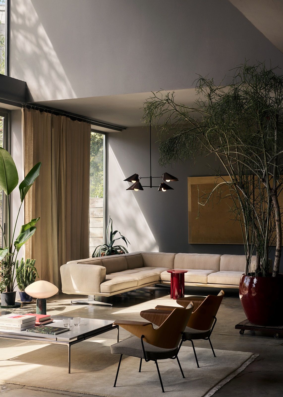 Wohnzimmer mit RFH Robin Day Sessel, Design-Sessel und beigem Ecksofa in modernem Ambiente.