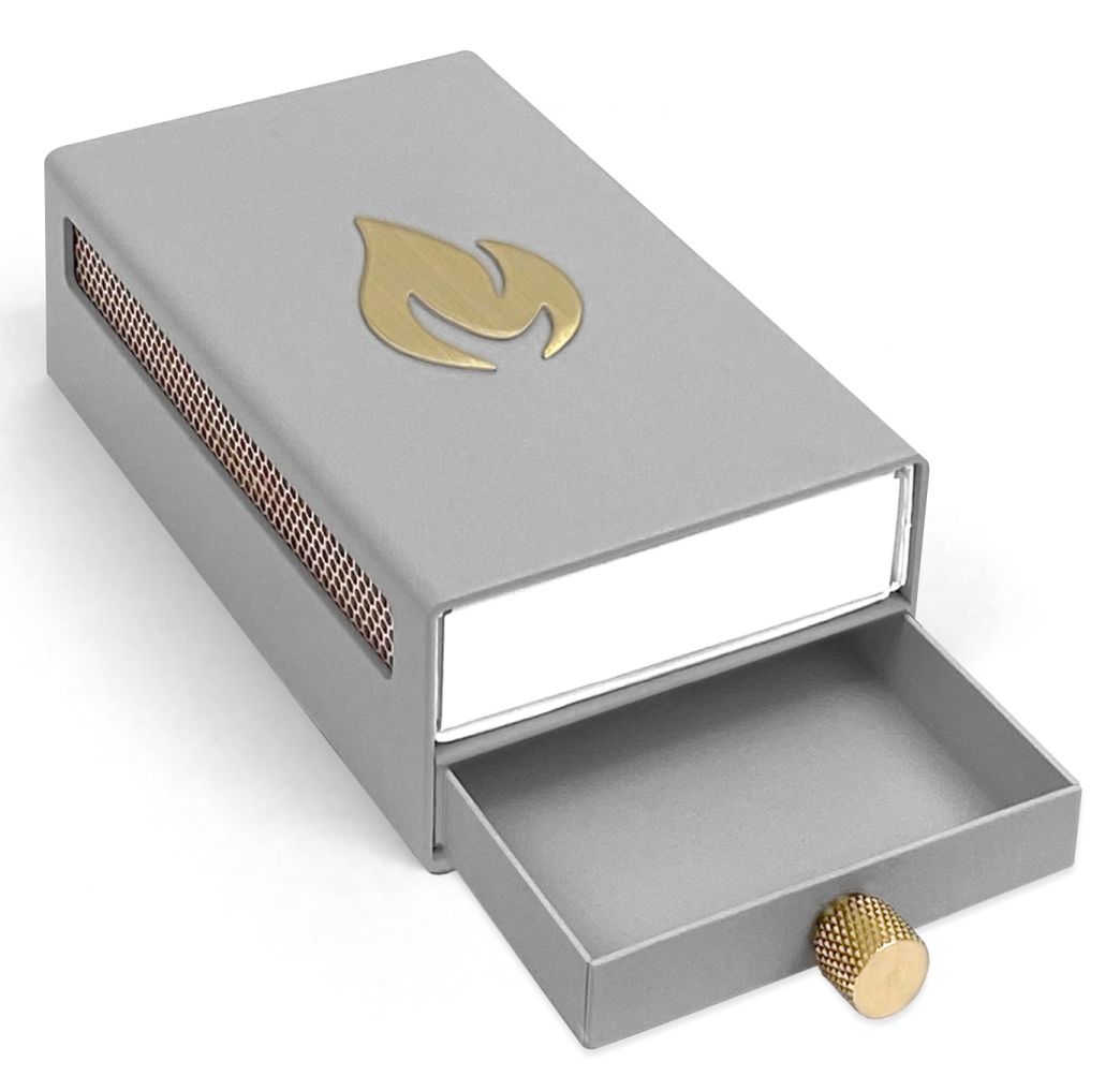 Graue Design Streichholzschachtel-Hülle mit goldenem Flammen-Motiv und ausziehbarer Schublade. Dekorative Zündholzbox für stilvolles Anzünden.