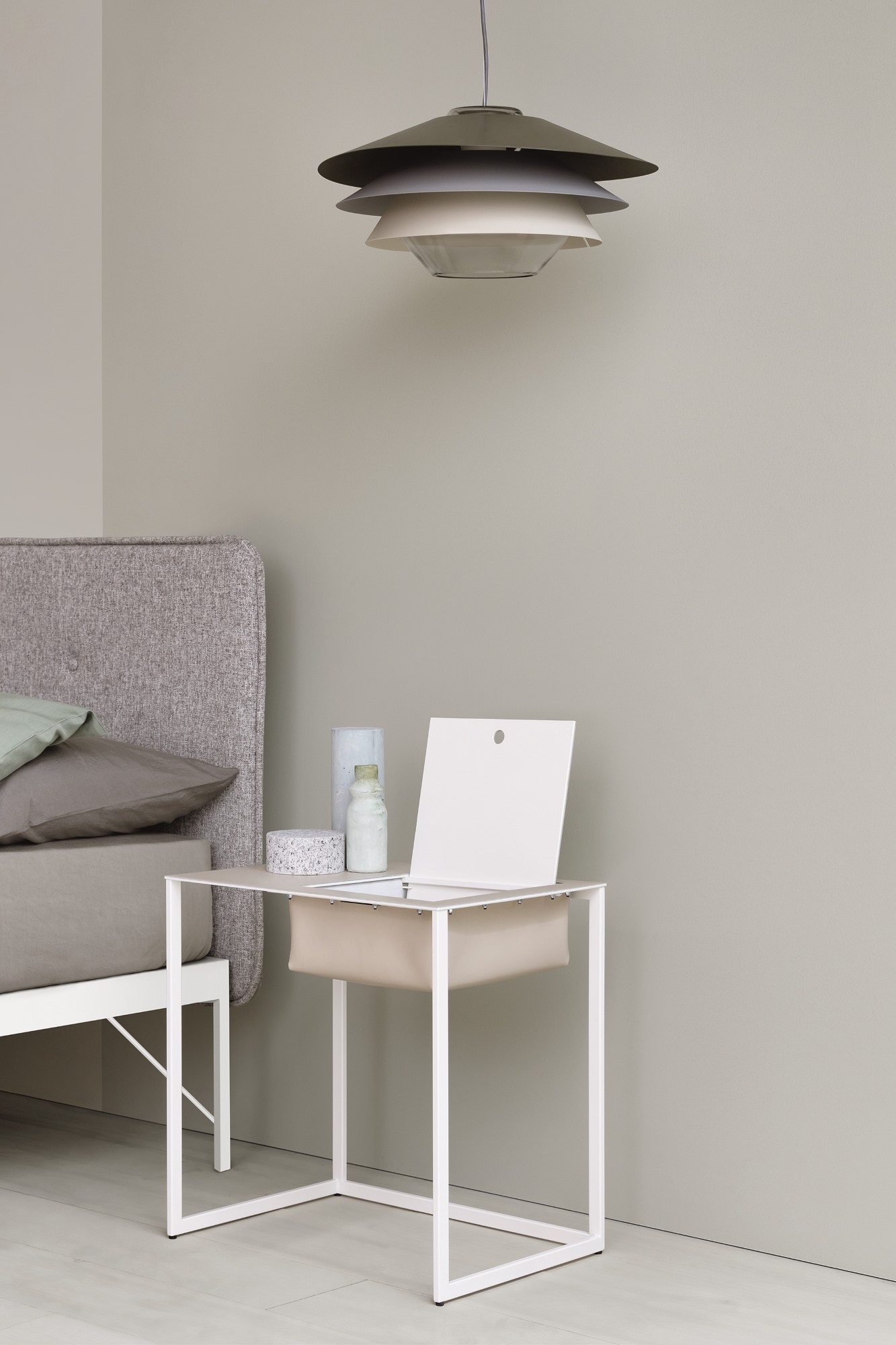 Moderner Nachttisch Taschino von Zanotta in Weiß mit Ablagefach neben einem Bett.