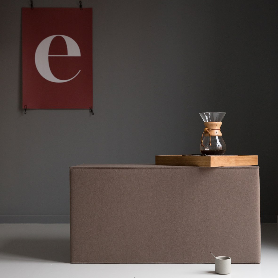 Brauner Quader Sitzhocker von Hey Sign mit Kaffeebereiter und Tasse im minimalistischen Raum.