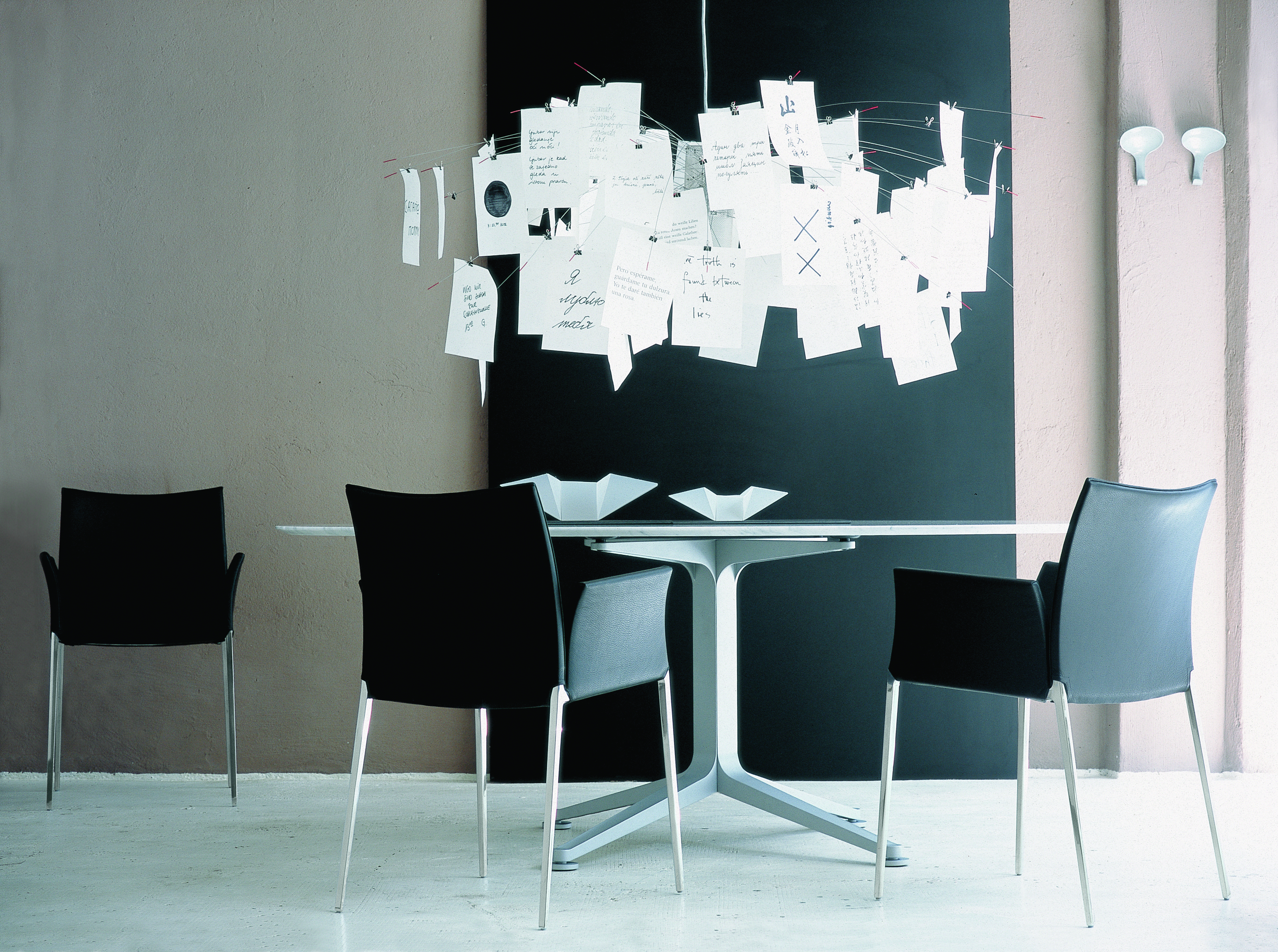 Schwarzer Lia Stuhl mit Armlehnen von Zanotta am Esstisch, modernes Design, minimalistisch.