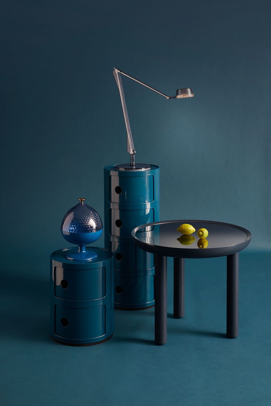 Grüne Componibili Aufbewahrungselemente von Kartell, modulare Regale mit Fächern und einem Tisch mit Zitronen.