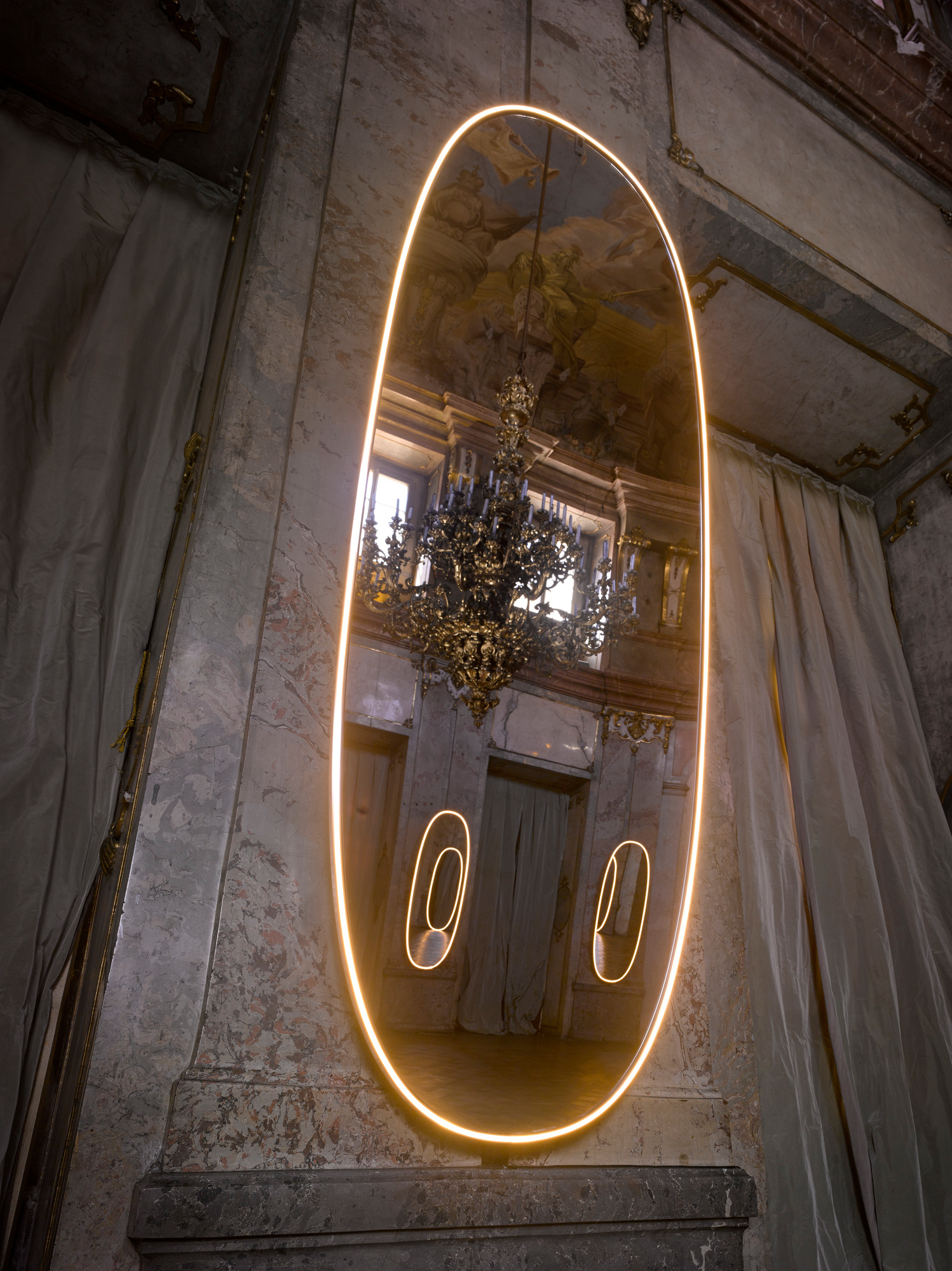 La Plus Belle Wandleuchte von Flos: Ovaler Lichtspiegel mit Aluminiumrahmen und warmem LED-Licht.