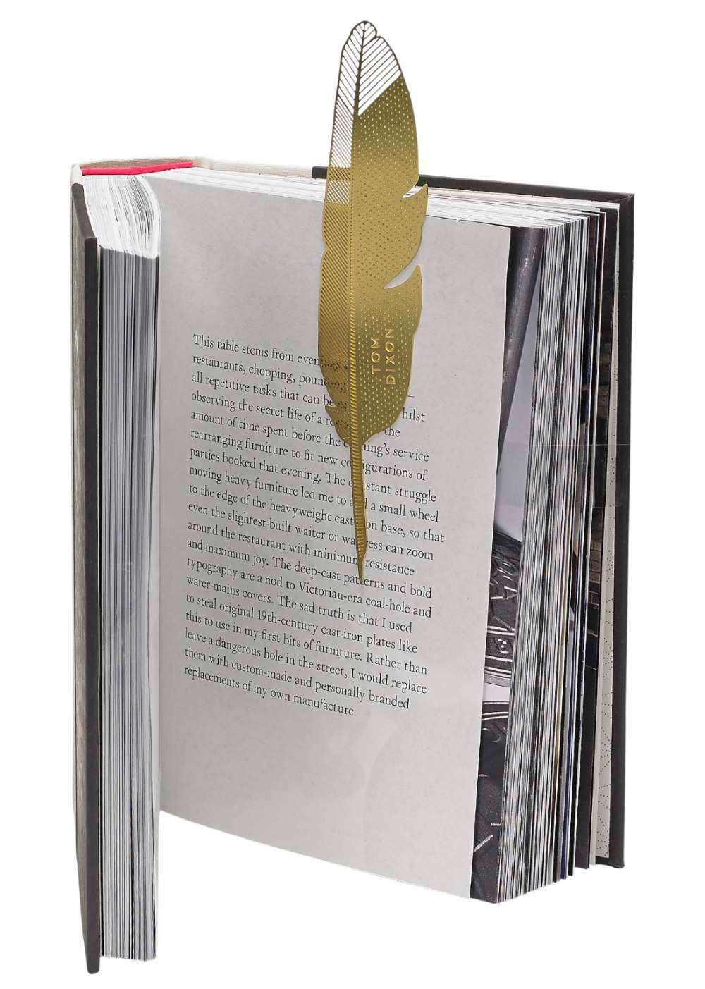 Goldfarbenes Tool the Bookworm Quill Lesezeichen von Tom Dixon steckt in einem Buch.