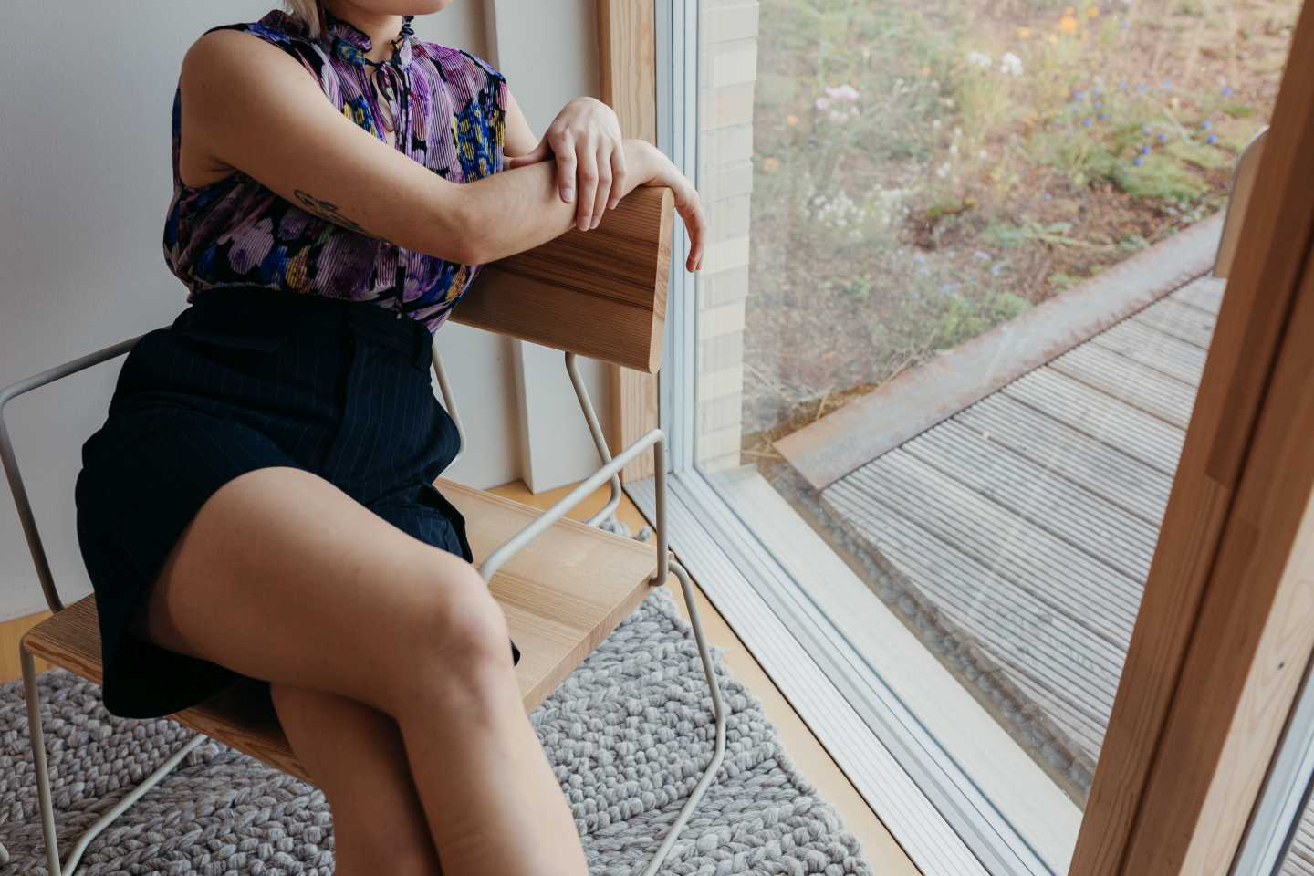 Frau sitzt auf D:008 Loungechair mit Armlehnen. Waldgrüner Sessel für Wohnzimmer und Terrasse.