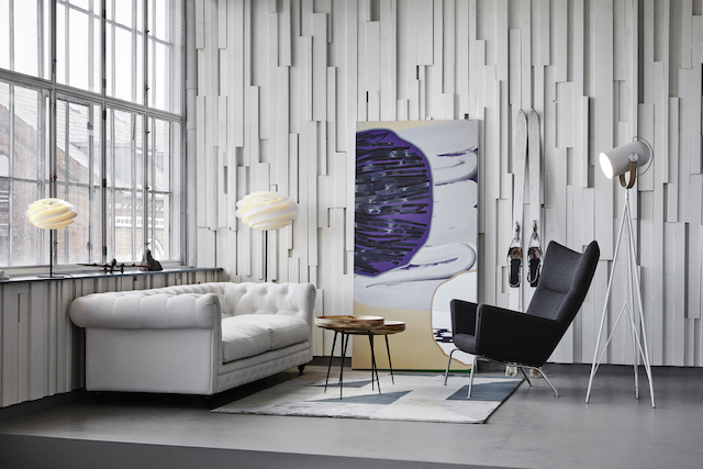 Swirl Stehleuchte von Le Klint in modernem Wohnzimmer mit Designermöbeln und Kunst.