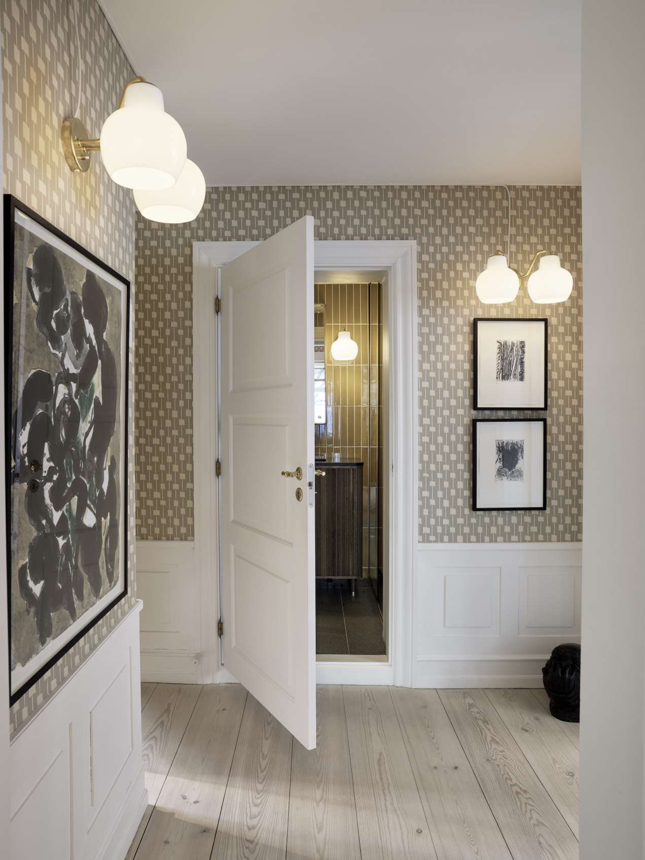 Flur mit VL Ring Crown Wandleuchten von Louis Poulsen, die warmes Licht spenden.