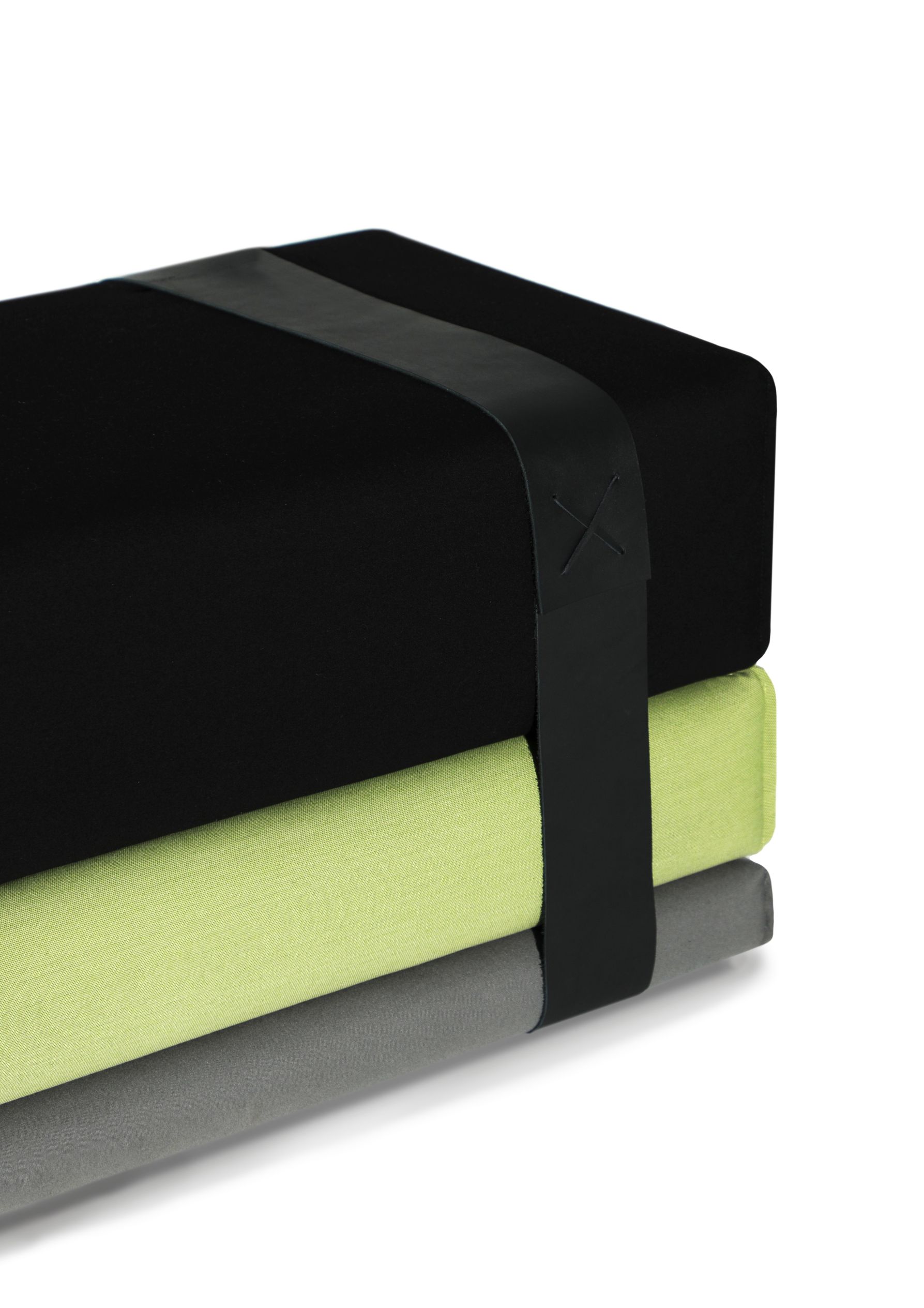 Bavul Bank von Prostoria: Stapelbare Sitzkissen in Schwarz, Grün und Grau mit Lederband.