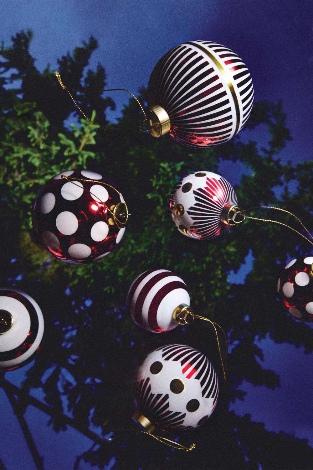 Alessi Weihnachtskugeln NZ04 Delight mit Streifen und Punkten am Weihnachtsbaum, festliche Dekoration.