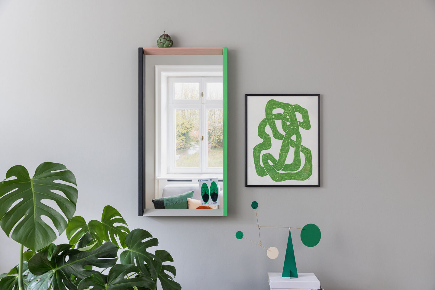 Colour Frame Mirrors Spiegel von Vitra an grauer Wand mit Dekoration und Zimmerpflanze.