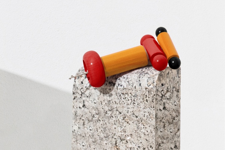 Alessi Korkenzieher ES17 EINZELSTÜCK in Rot und Gelb auf einem Steinsockel. Design Korkenzieher.
