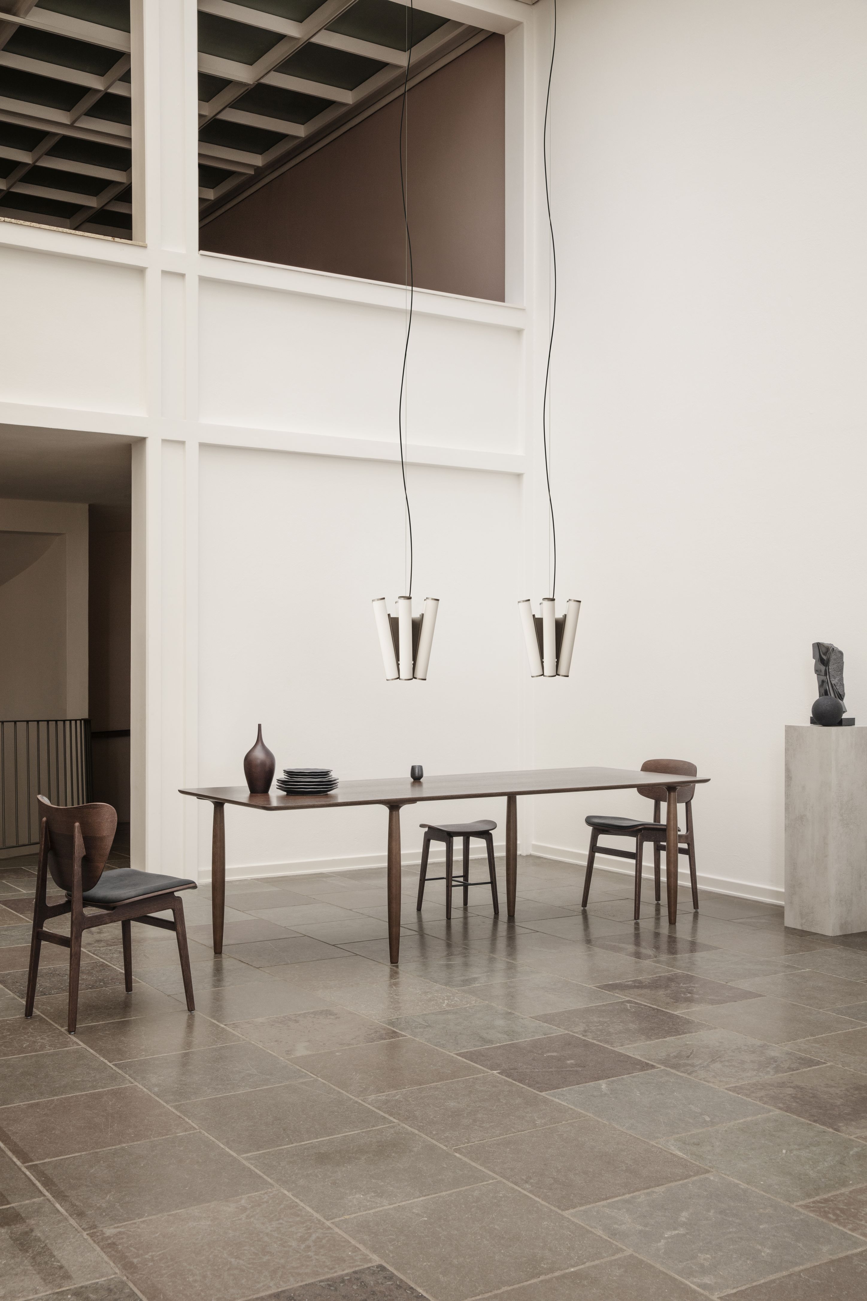 Oku Esstisch Eiche schwarz von Norr11, 200 cm breit, mit Stühlen und Dekoration.