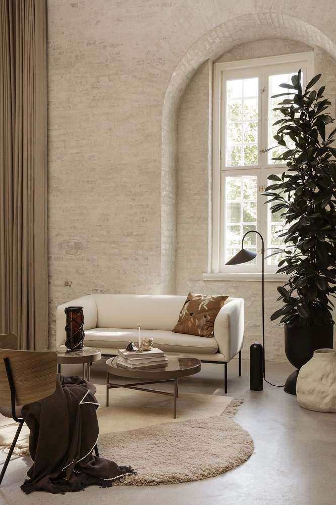 Wohnzimmer mit Ferm Living Marmor Beistelltisch, Sofa, Teppich und Zimmerpflanze in hellem Raum.