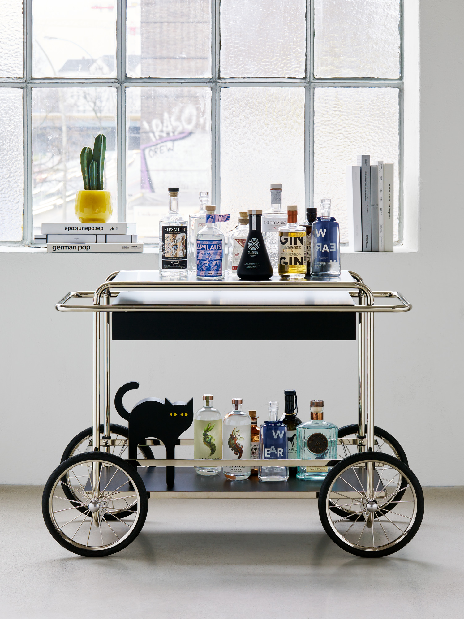 Produktfoto: Barwagen mit Getränken und Tecta Katze Holzfigur, modernes Möbeldesign für Wohnzimmer und Bar.