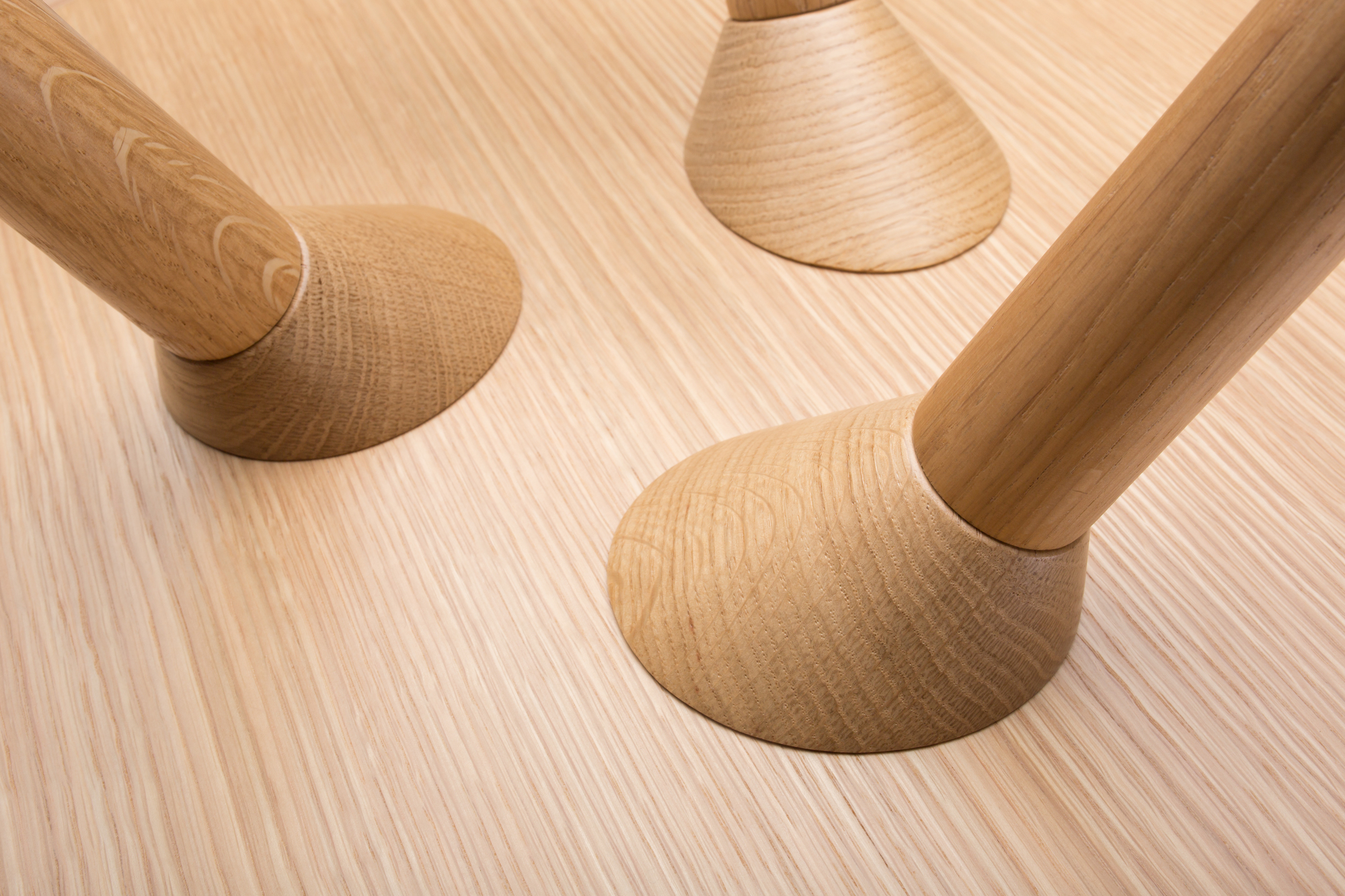 Detailaufnahme der Holzbeine des Maigrau Turn low Beistelltisches in Esche weiß, modernes Möbeldesign.