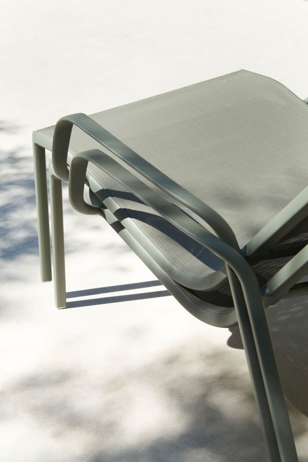 Detailaufnahme des Cadiz Lounge Sessels von Fermob für den Außenbereich mit grauem Metallrahmen und Textilbespannung.