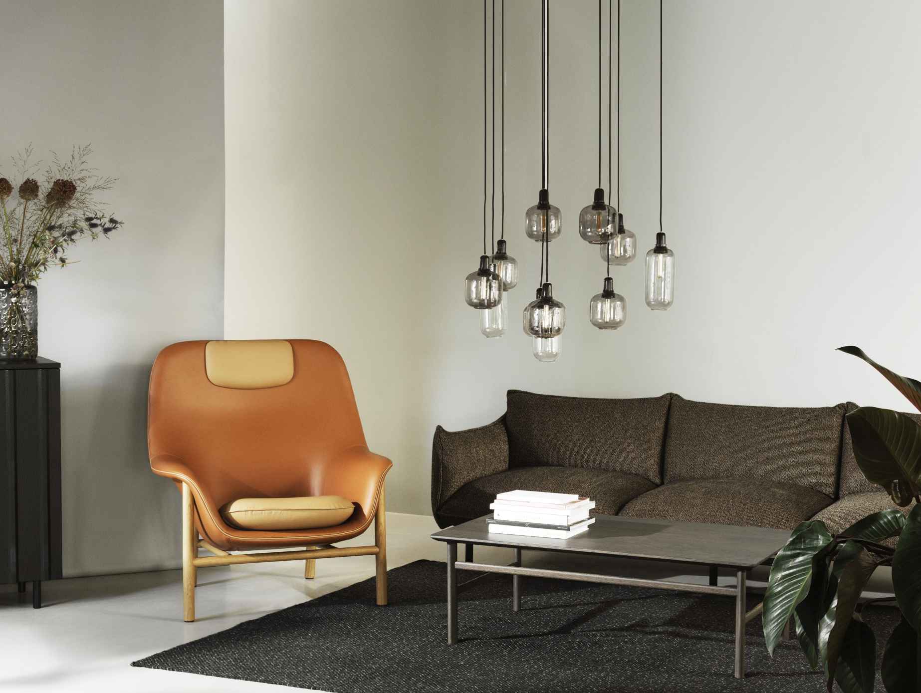 Wohnzimmer mit Normann Copenhagen Couchtisch, Sessel, Sofa und Pendelleuchten. Moderner Wohnstil.