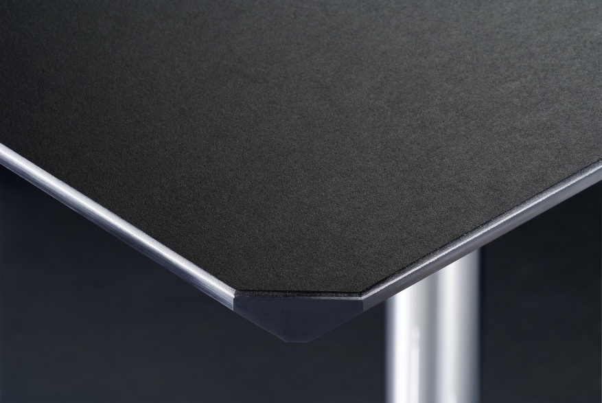 Detailaufnahme USM Haller Kitos M Schreibtisch mit Linoleumoberfläche in Nero und verchromtem Tischbein.