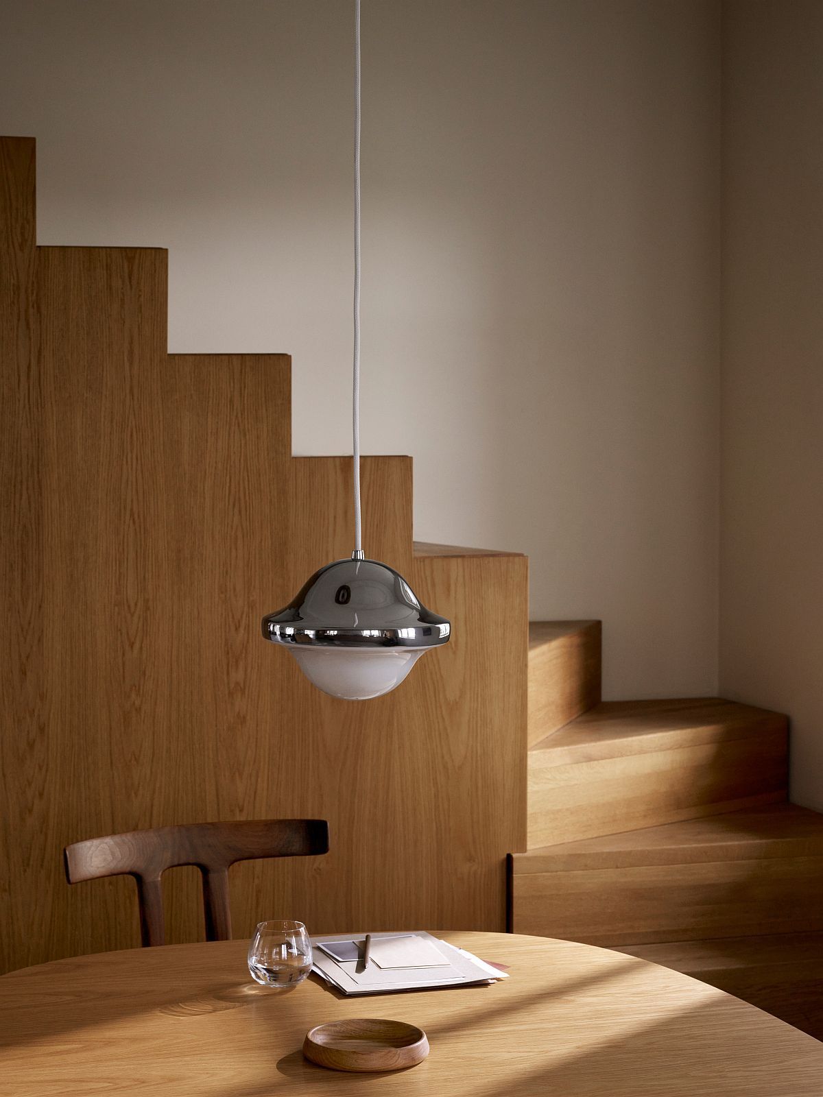 HK20 Bubi Pendelleuchte von Carl Hansen & Søn über Holztisch und Treppe, modernes Design.