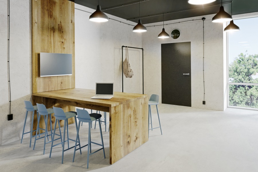 Treet Trebord Konferenztisch aus hellem Holz mit blauen Barhockern in modernem Büro.