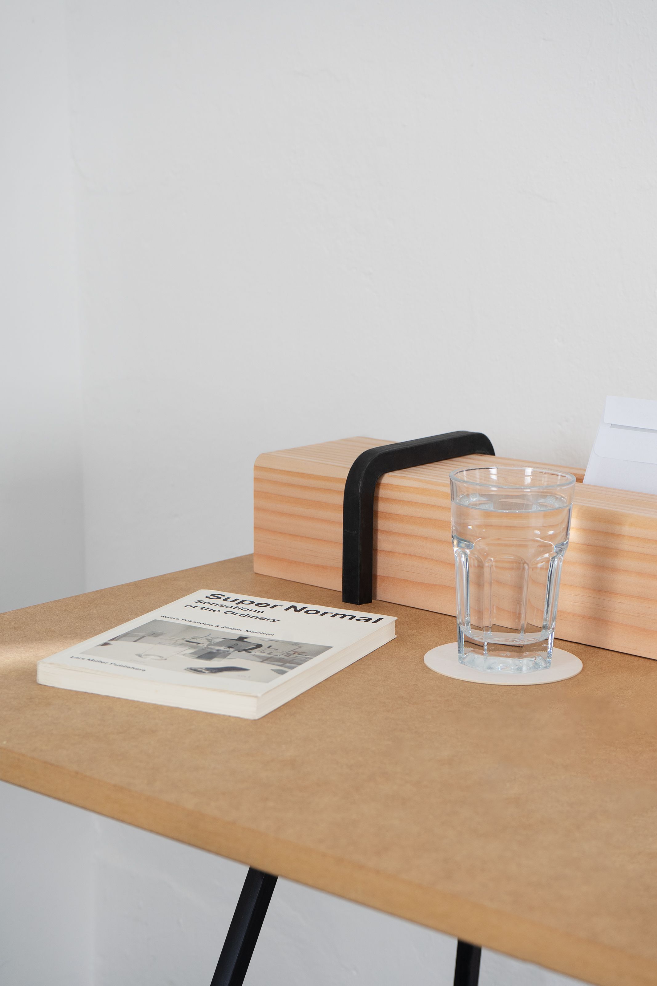 Detailaufnahme des Kurt Sekretärs von Moormann mit Buch und Glas Wasser auf der Tischplatte.