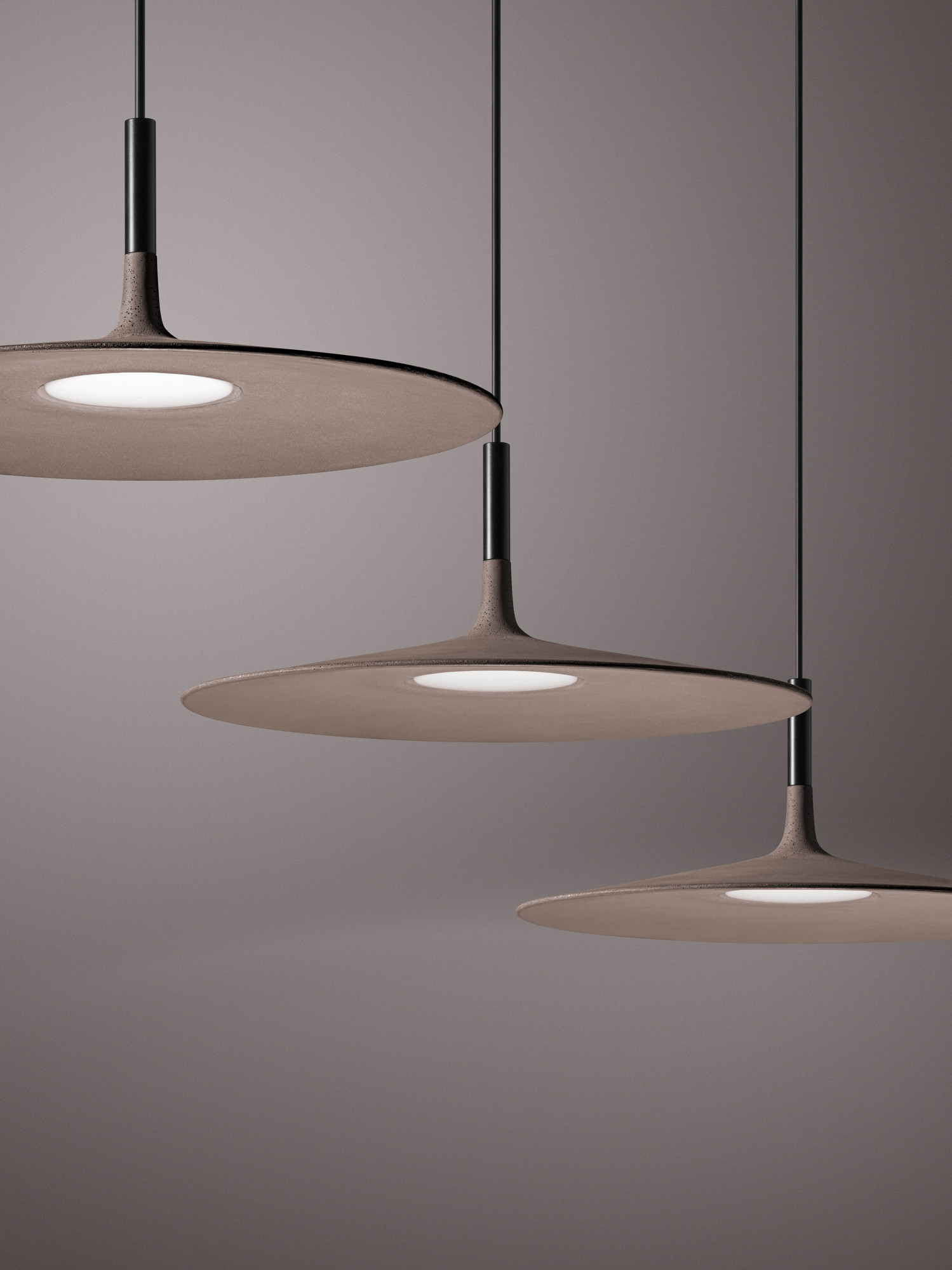 Drei graue Aplomb LED Pendelleuchten von Foscarini mit runder Form und modernem Design.