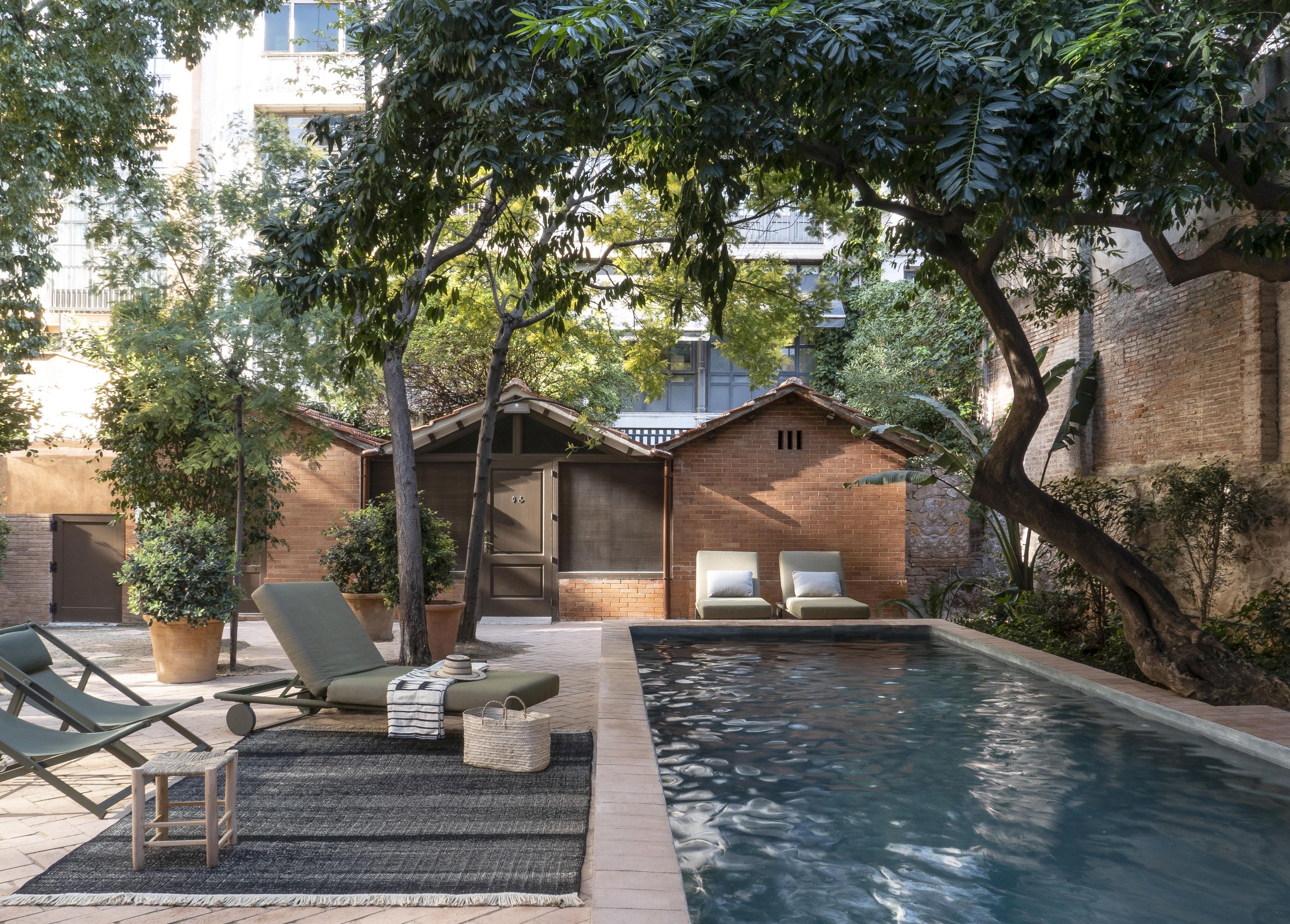 Tres Outdoor Teppich von Nanimarquina in Senf, 300x400 cm, auf Terrasse mit Pool und Liegen.