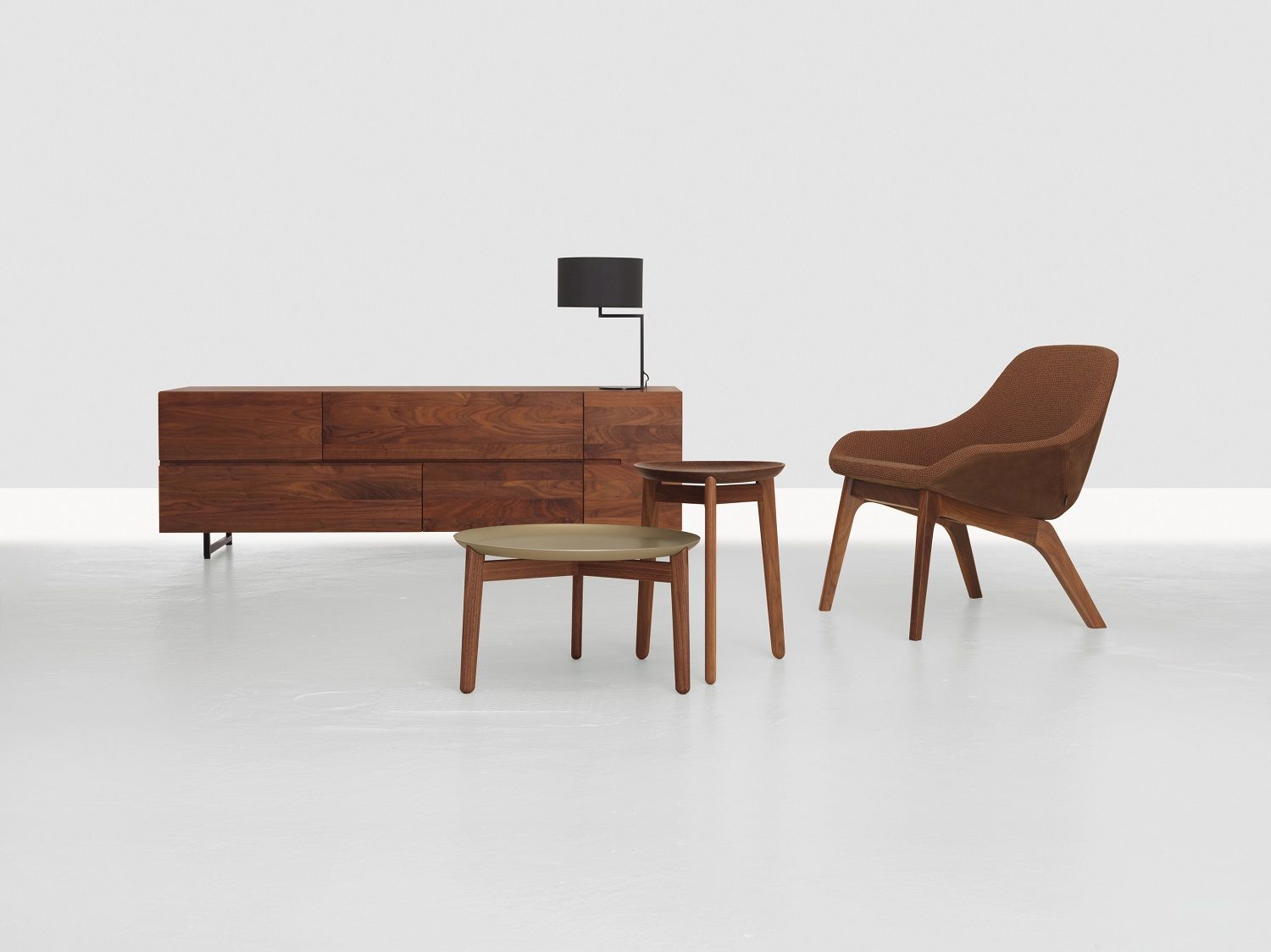 Low Sideboard aus Massivholz mit passendem Sessel und Beistelltischen in einem minimalistischen Raum.