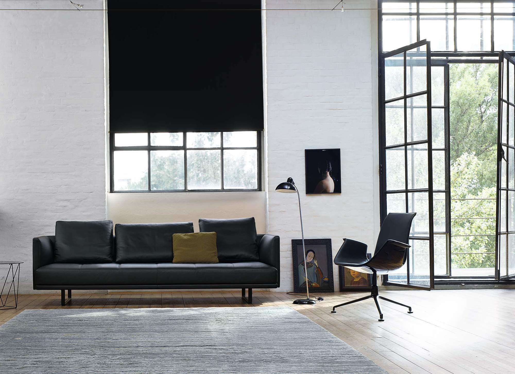 Schwarzes Prime Time Sofa von Walter Knoll in modernem Wohnzimmer mit Sessel und Teppich.
