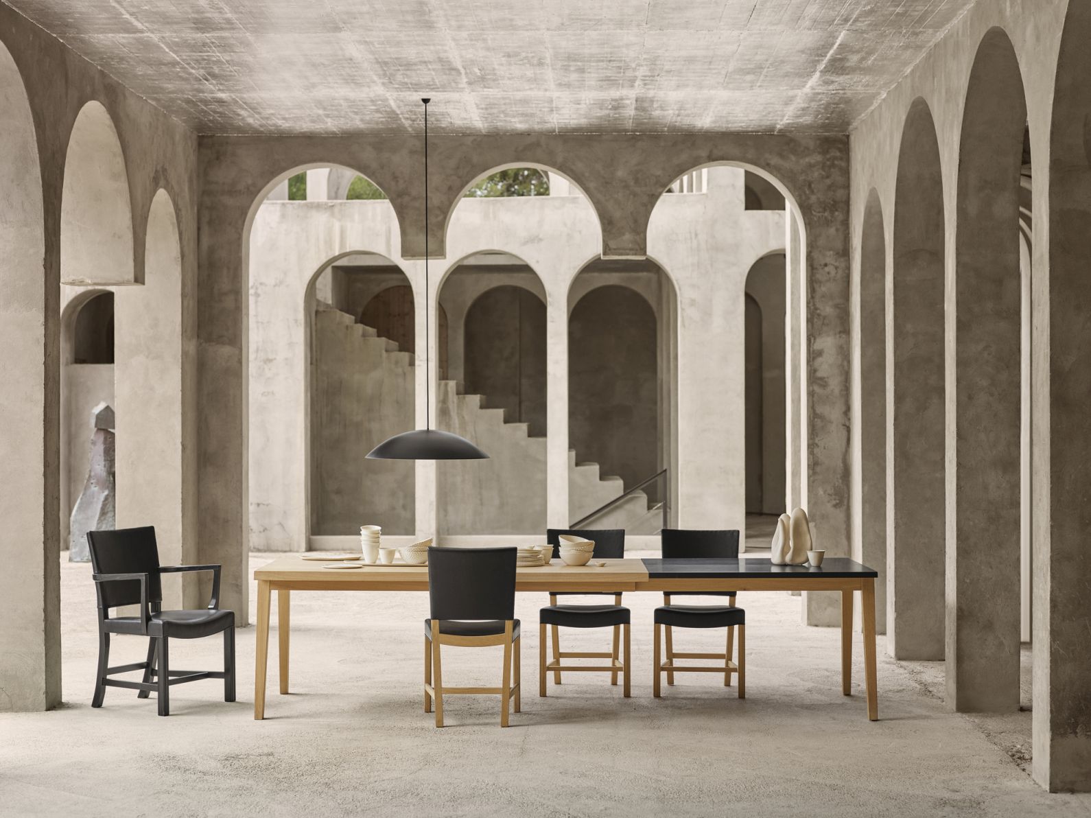 BT1041 Calot Pendelleuchte von Carl Hansen & Søn über Esstisch mit Stühlen in modernem Ambiente.