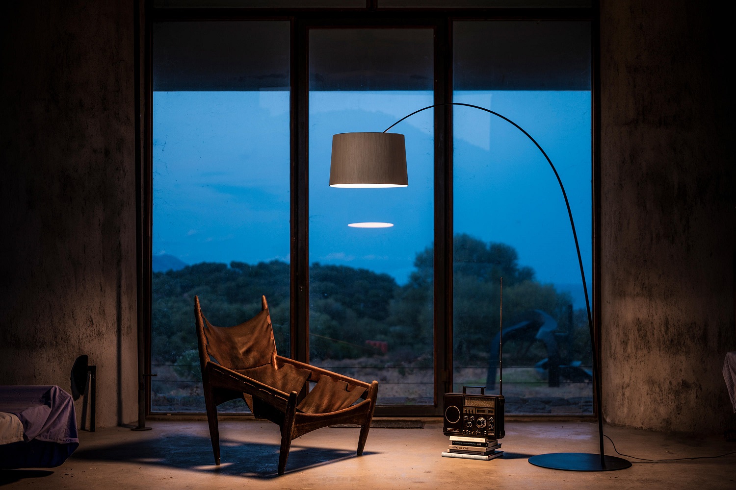 Graue Twiggy LED Stehleuchte von Foscarini im modernen Wohnzimmer mit Sessel und Radio.