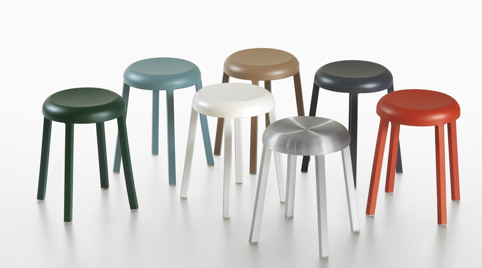 Gruppenbild von sieben farbigen Za Stool Hockern von Emeco, darunter ein Hocker aus poliertem Aluminium.