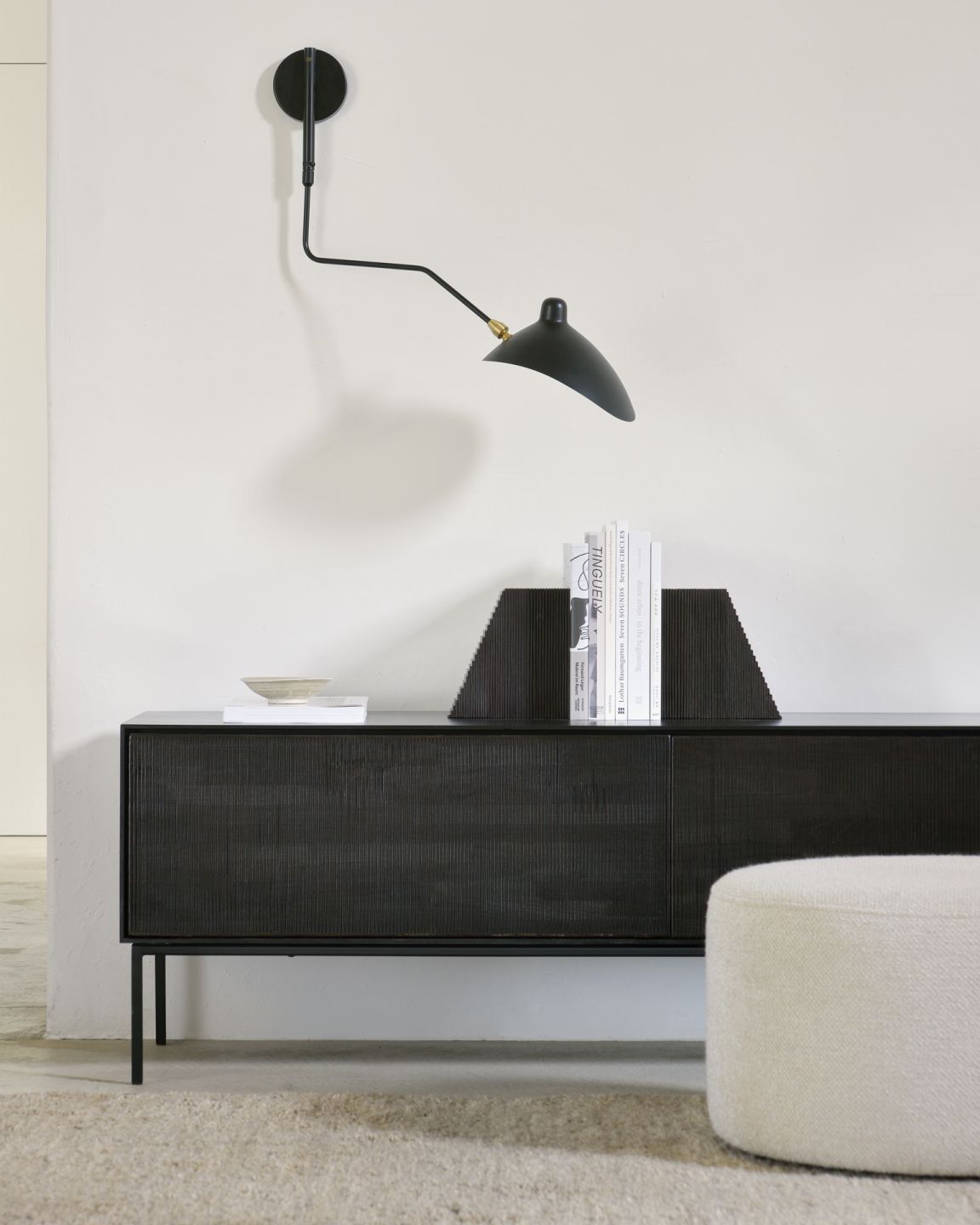 Barrow Sitzhocker in Off White vor dunklem Sideboard, stilvoller Hocker für Wohnzimmer und mehr.