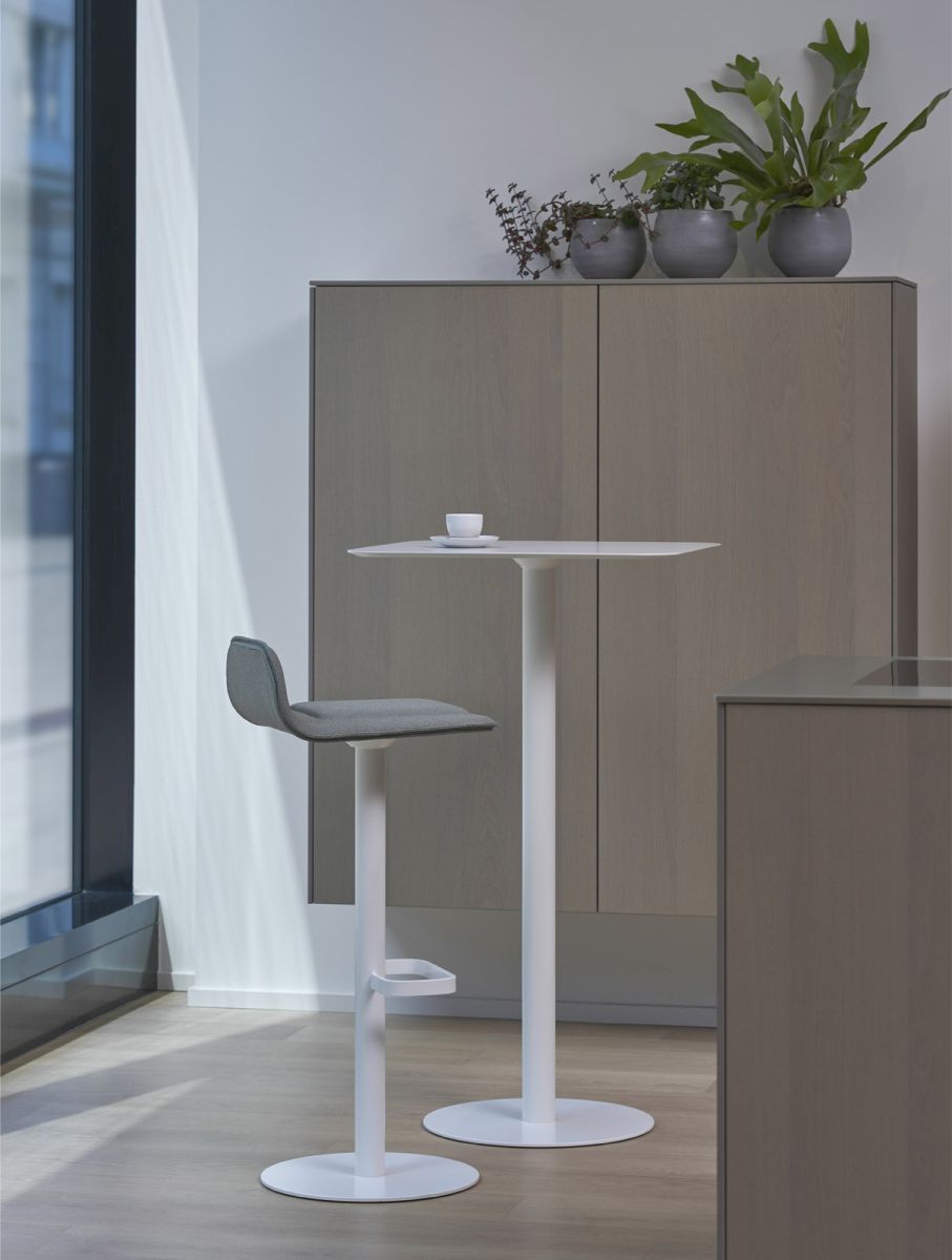 Moderner Dave Barhocker in Weiß mit salbeifarbenem Sitzpolster vor hellem Hintergrund. Barstuhl für Küche oder Bar.