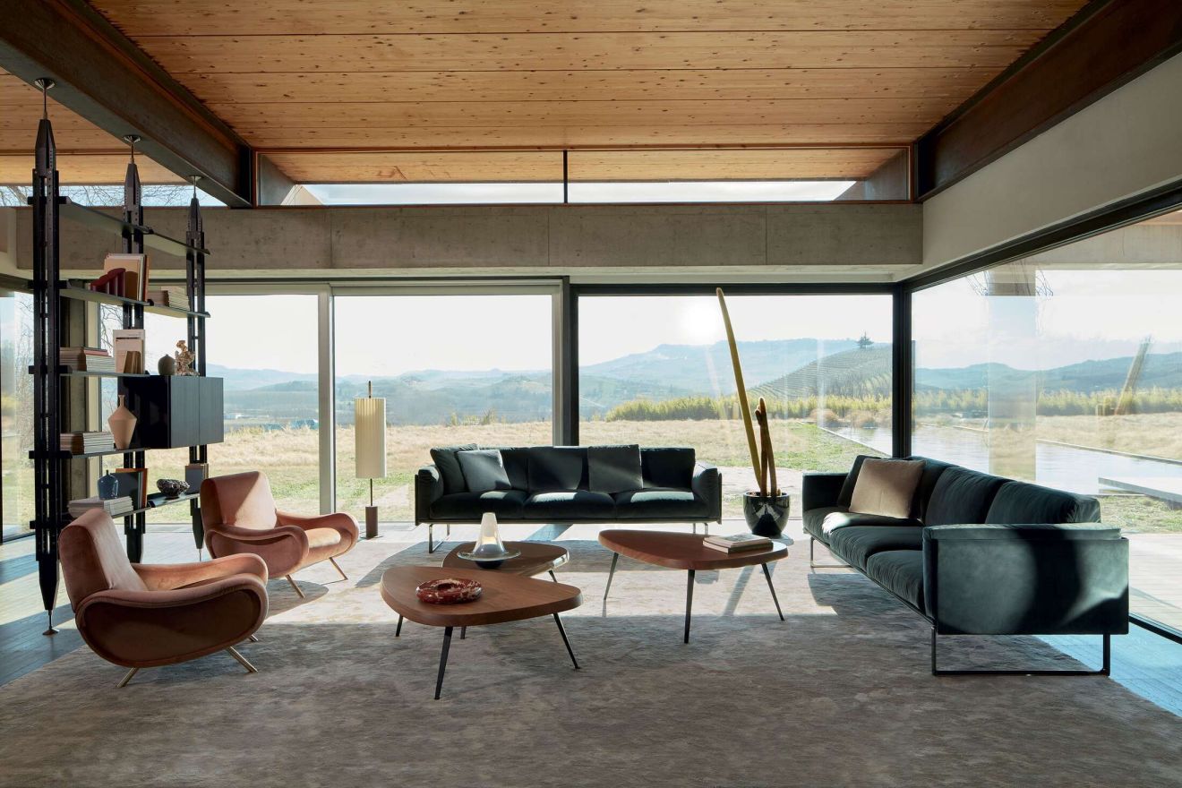 Helles Wohnzimmer mit Cassina 3-Sitzer Sofa, Sesseln und Couchtischen. Moderne Möbel für stilvolles Wohnen.