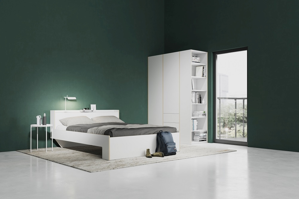 Weißes Bett mit Müller Möbelwerkstätten Stirnelement Regal und passendem Kleiderschrank im Schlafzimmer.