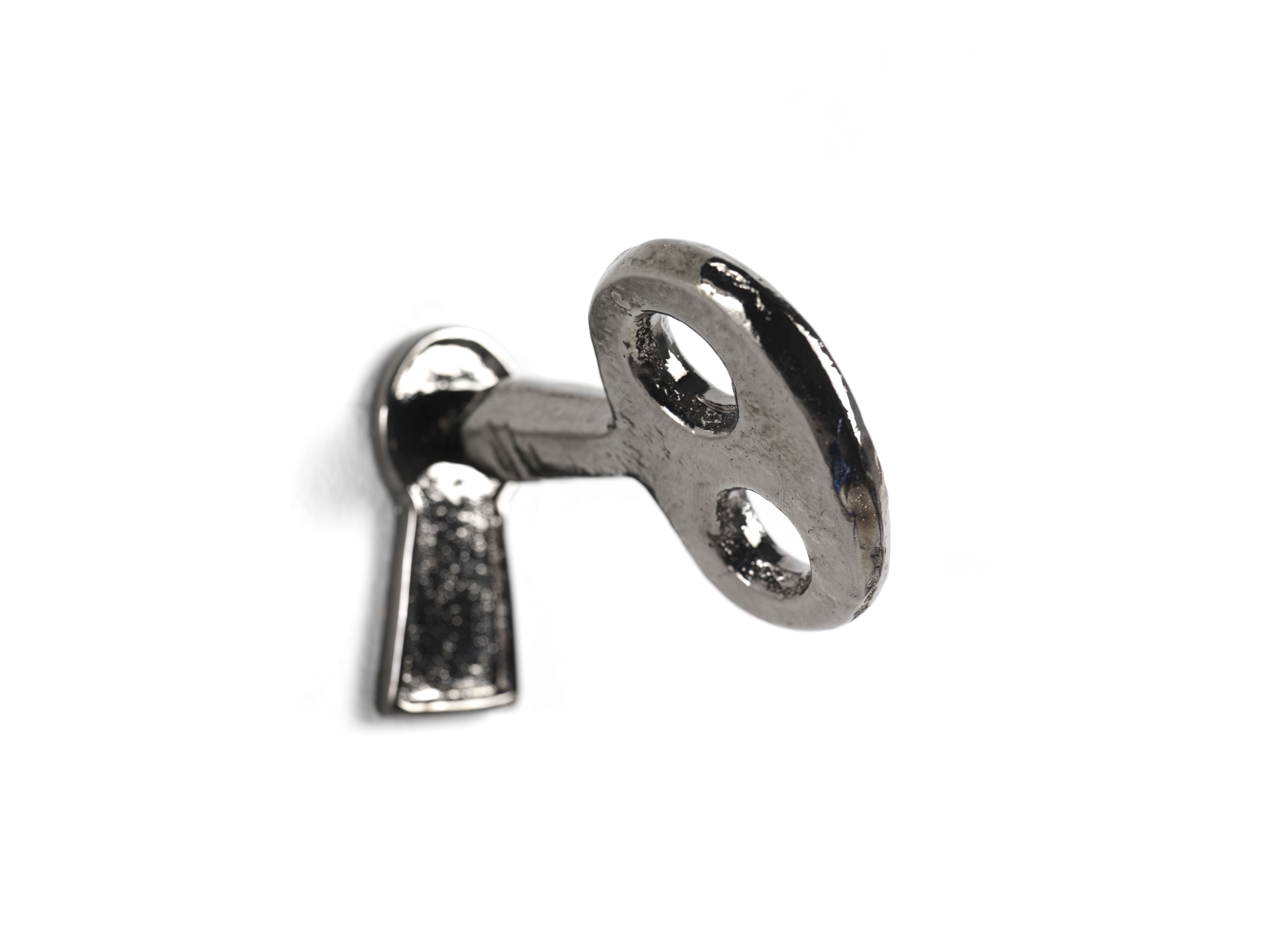 Detailaufnahme eines Memorie Wandhakens von Mogg in Schlüsselform, silberfarben.