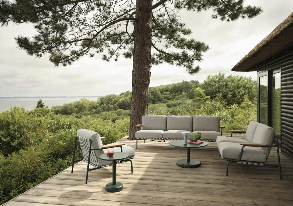 Muuto Settle Outdoor Sofa 3-Sitzer und Sessel auf Holzterrasse mit Meerblick, modernes Gartenmöbel-Set.