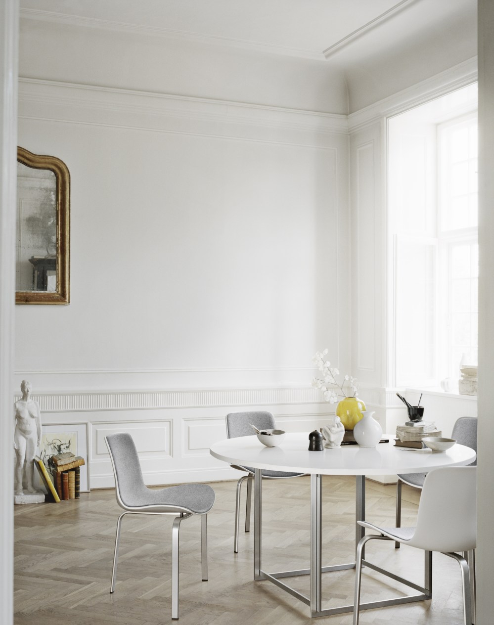 Heller Raum mit PK58 Esstisch von Fritz Hansen, runder Tisch mit Stahlgestell und Stühlen.