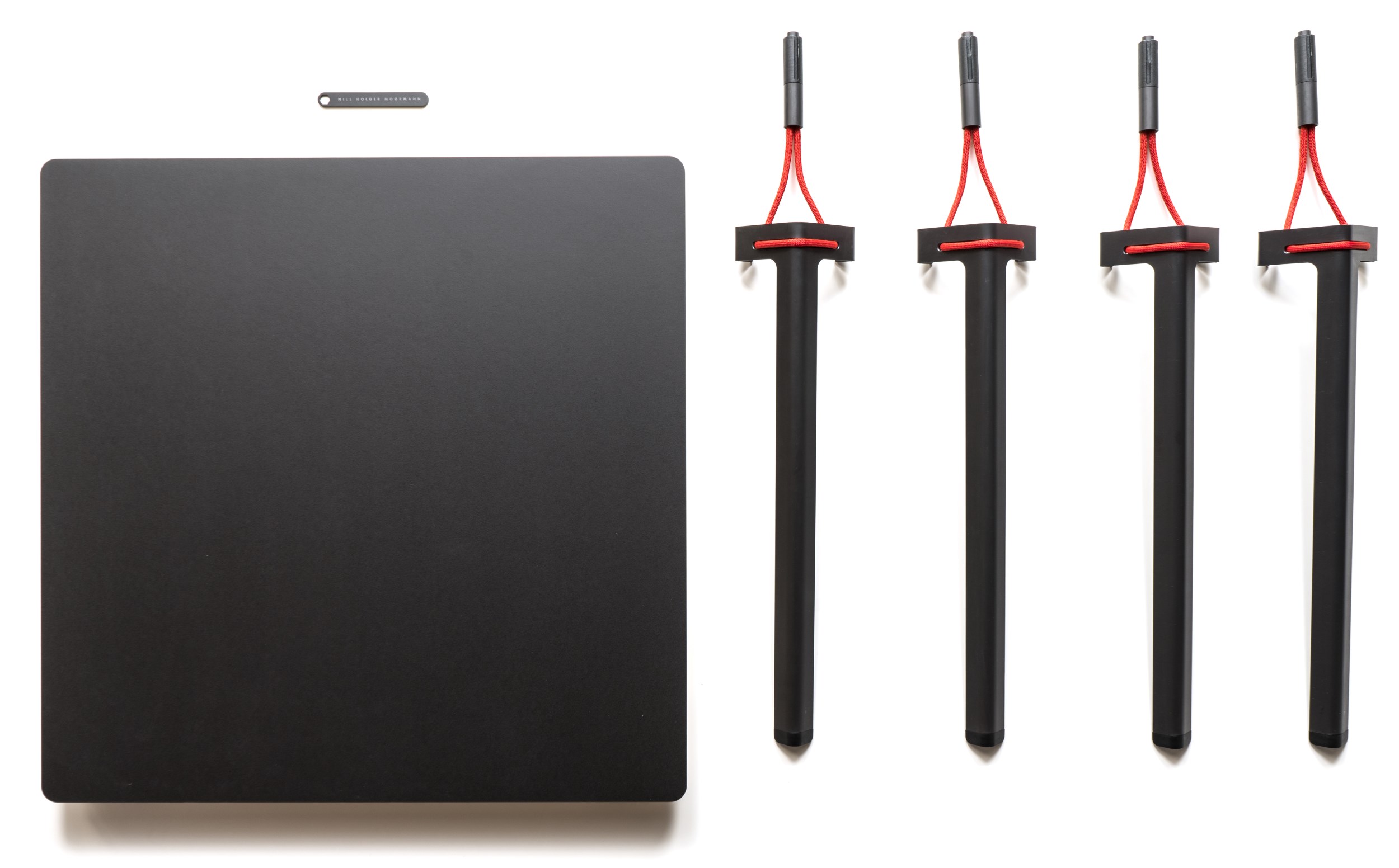 Schwarzer Seiltänzer Tisch von Nils Holger Moormann mit drei Tischbeinen und roter Seilaufhängung.