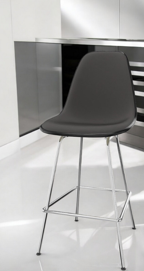Schwarzer Eames Plastic Bar Stool Barhocker von Vitra mit verchromtem Gestell vor moderner Küchenzeile.