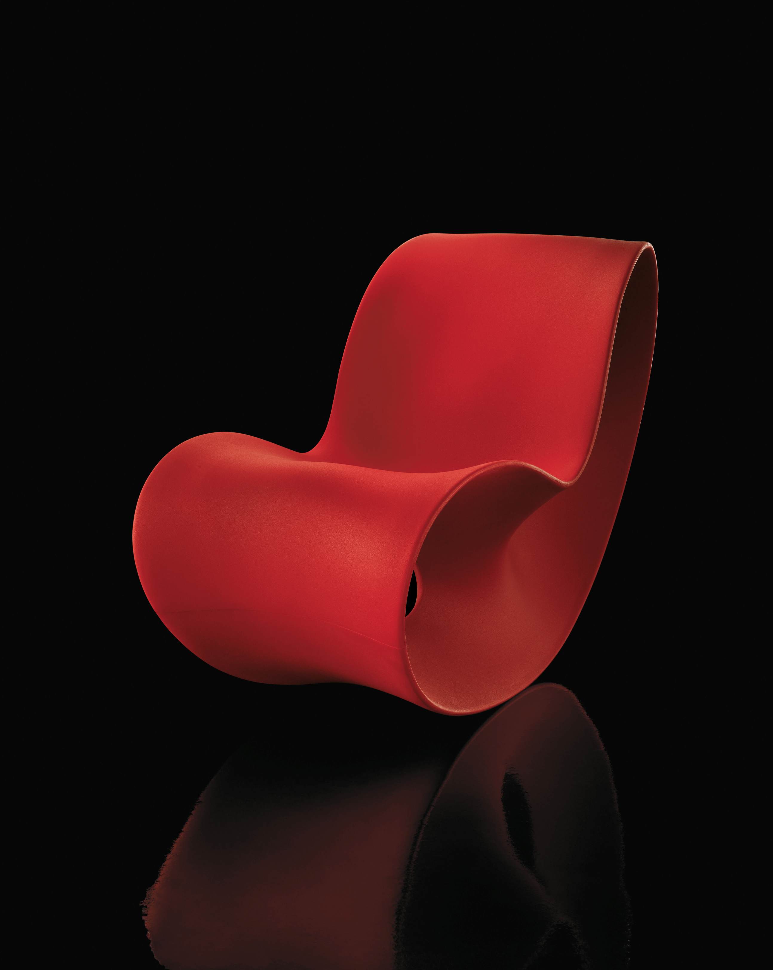 Roter VOIDO Schaukelstuhl von Magis, modernes Designmöbel für Wohnzimmer und Kinderzimmer, Kunststoffstuhl auf schwarzem Hintergrund.