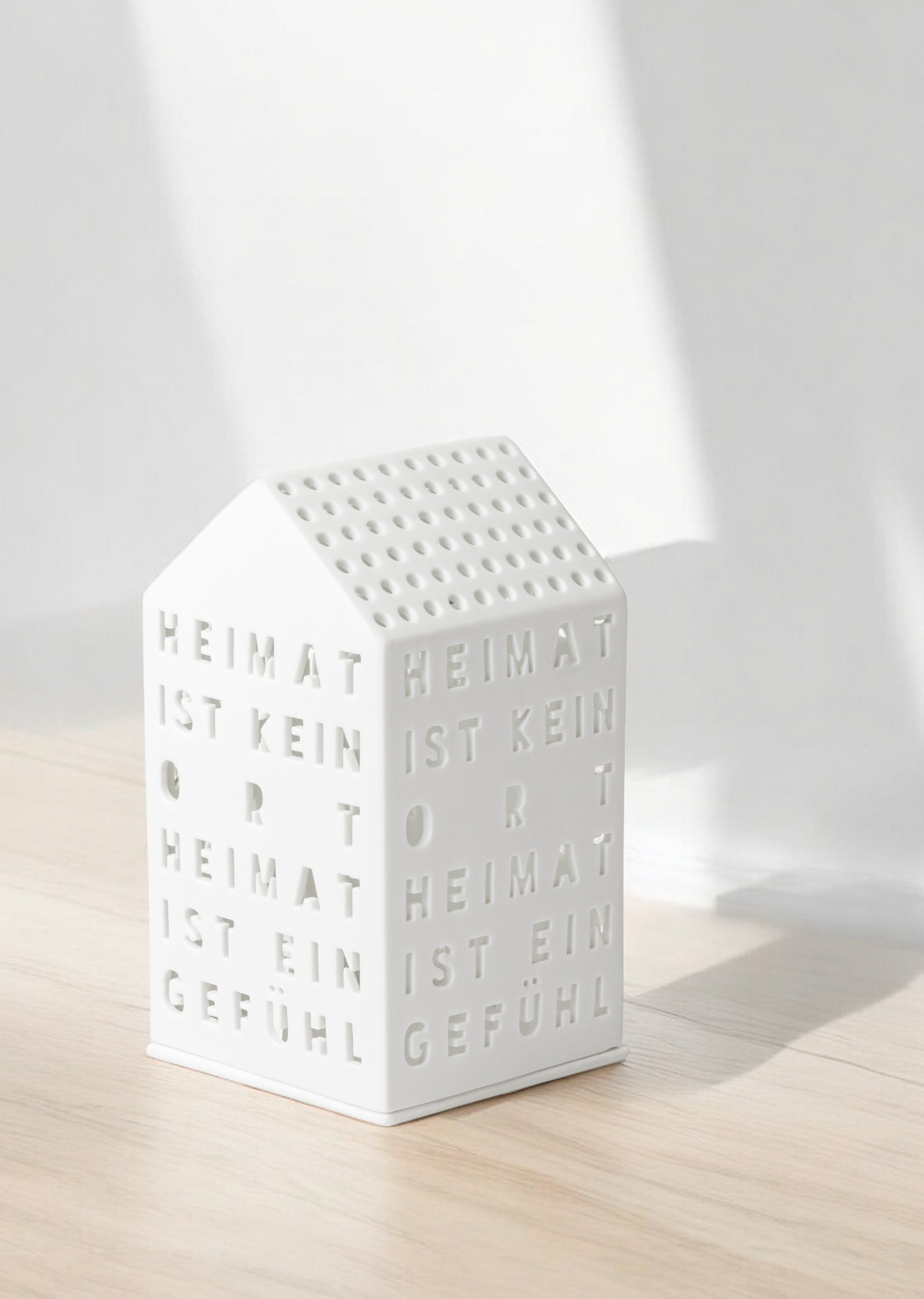 Weißes Lichthaus "Heimat ist kein Ort" von Räder, stimmungsvolle Dekoration für Zuhause.