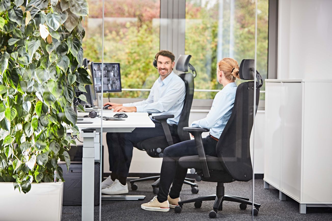 Büroszene mit zwei Personen auf Interstuhl Twentyfour Drehsesseln mit Kopfstütze bei der Arbeit.
