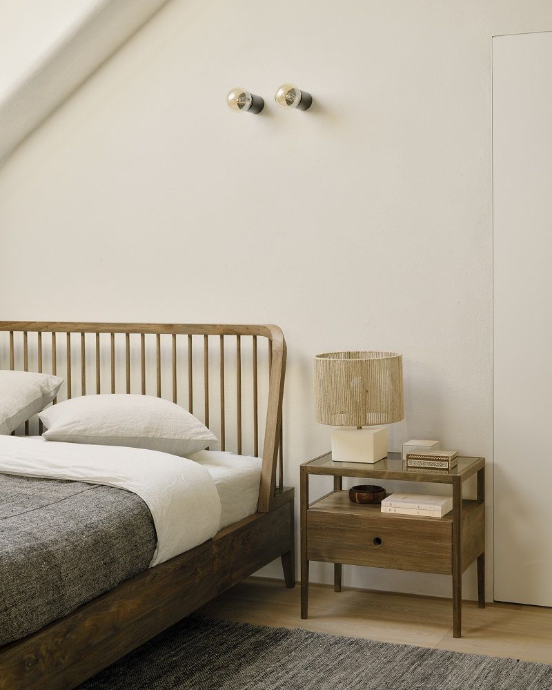 Spindle Bett aus Teakholz mit Lattenkopfteil und passendem Nachttisch im Schlafzimmer.