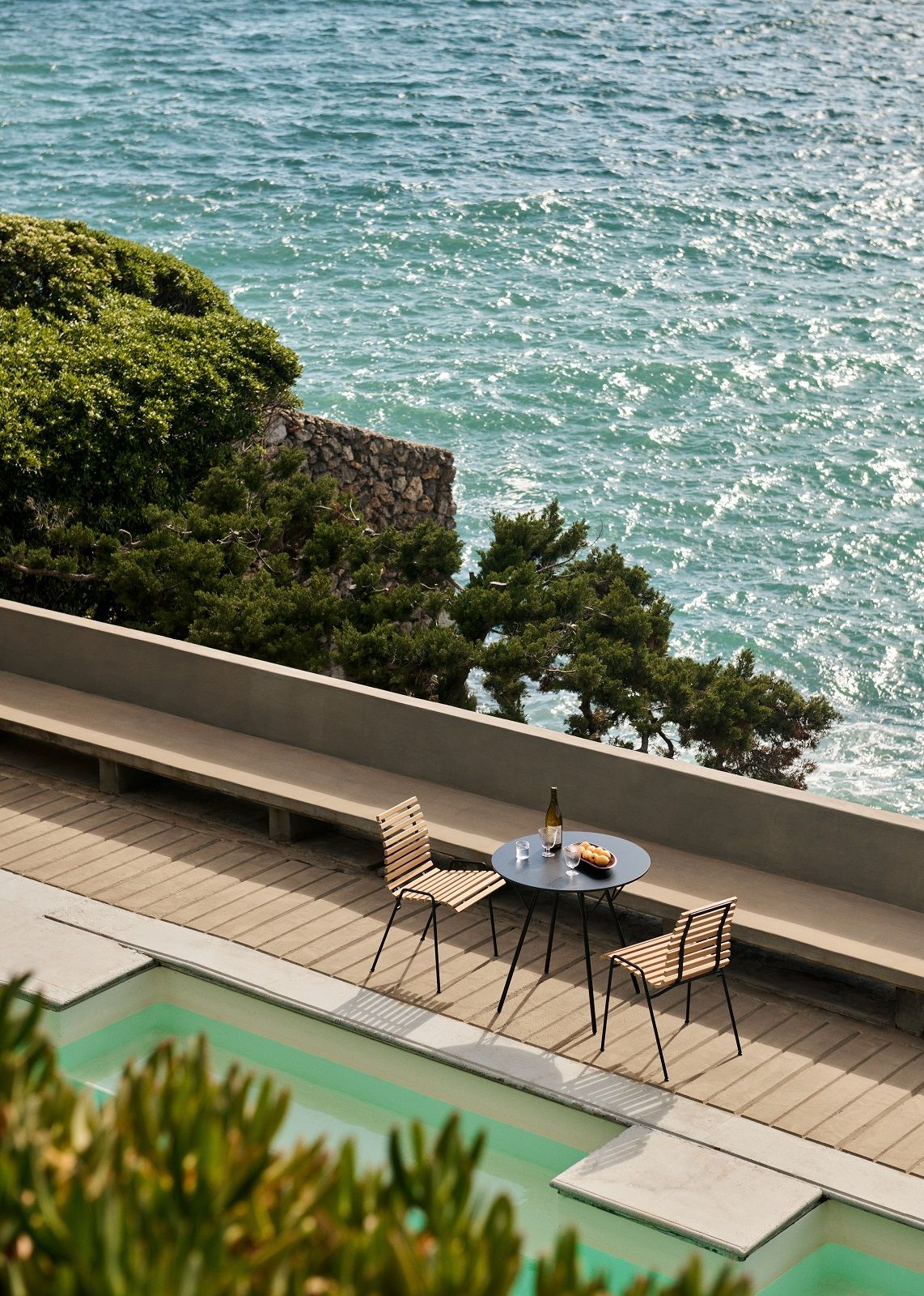 RFH Robin Day Esstisch für den Außenbereich mit Stühlen und Meerblick. Outdoor Möbel von AndTradition.