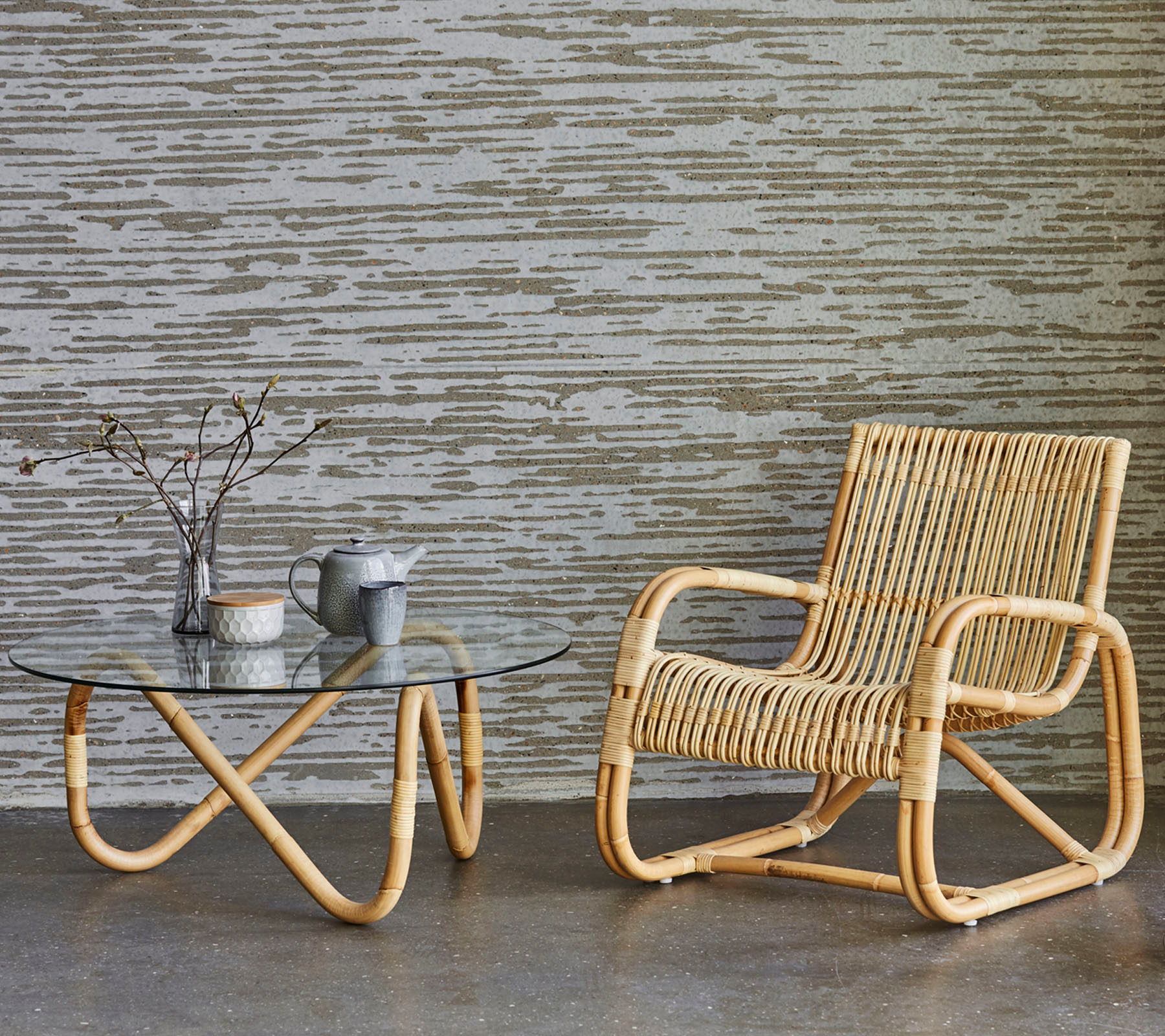 Cane-Line Curve Loungesessel Indoor aus Rattan mit passendem Couchtisch und Teegeschirr.
