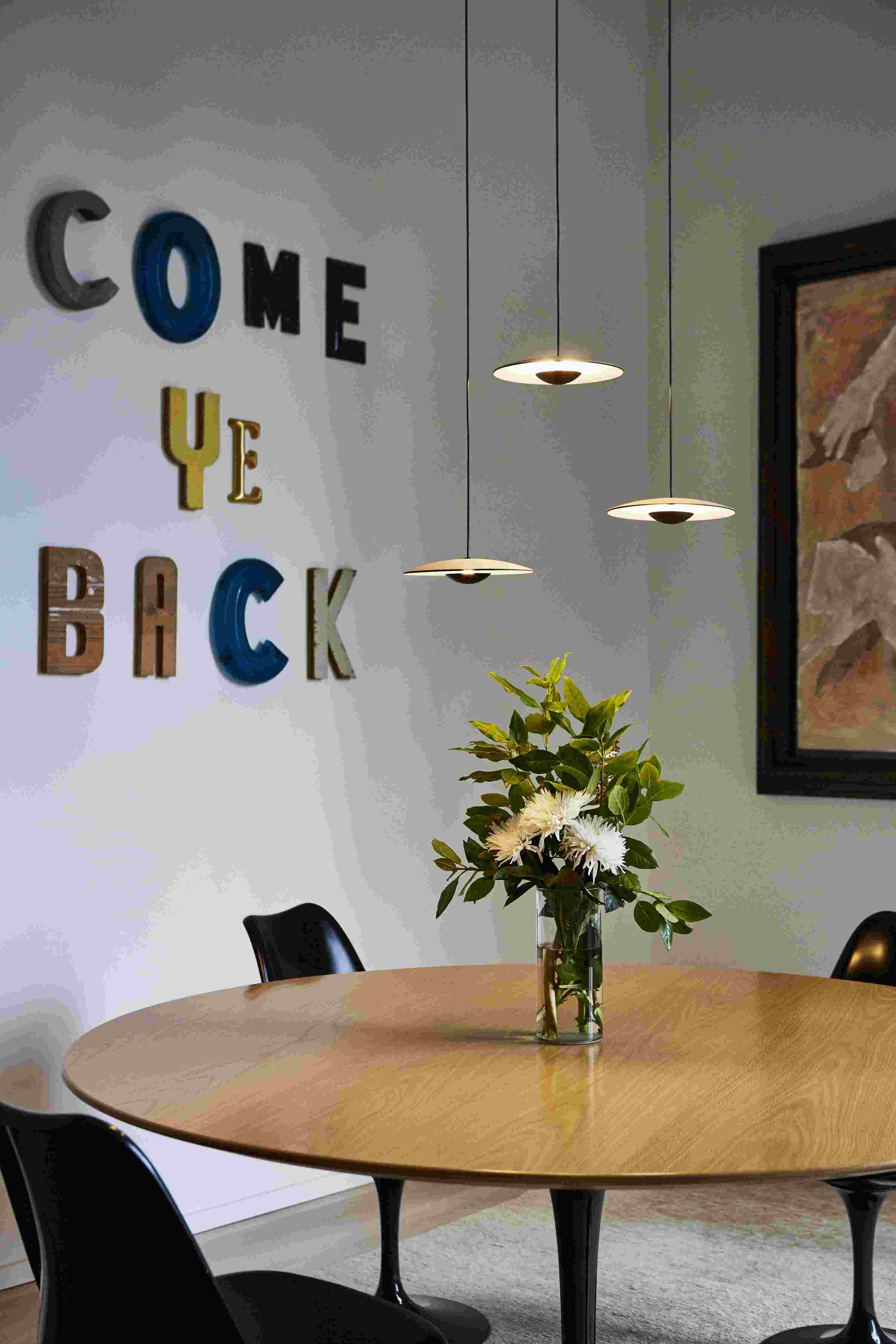 Ginger LED Pendelleuchte von Marset über Esstisch mit Blumen, modernes Design für Wohnzimmer.